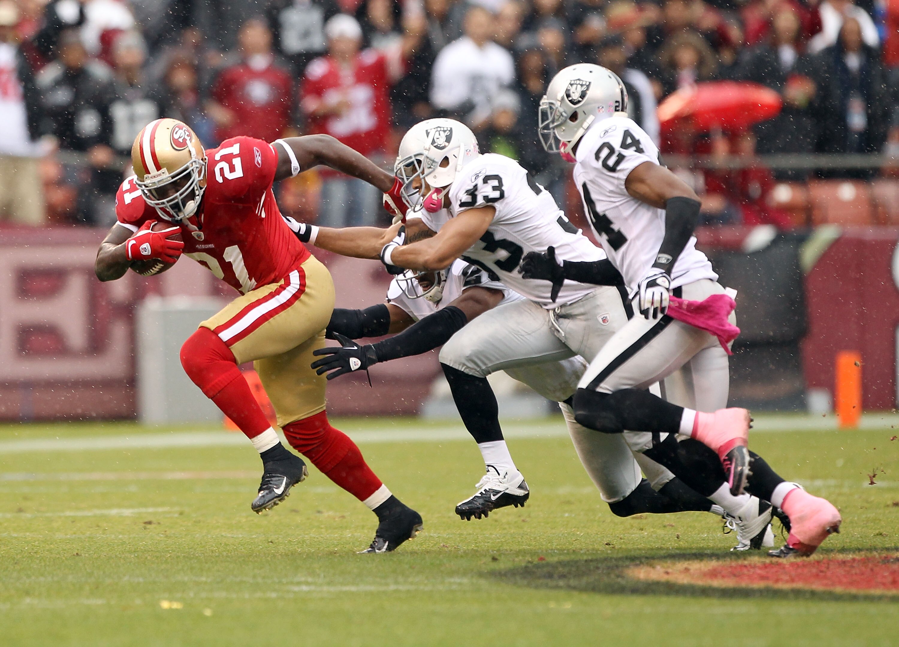 SAN FRANCISCO - OCTOBER 17:  Frank Gore #21 of the San Francisco 49ers tries to outrun the Oakland Raiders at Candlestick Park on October 17, 2010 in San Francisco, California.  (Photo by Ezra Shaw/Getty Images)