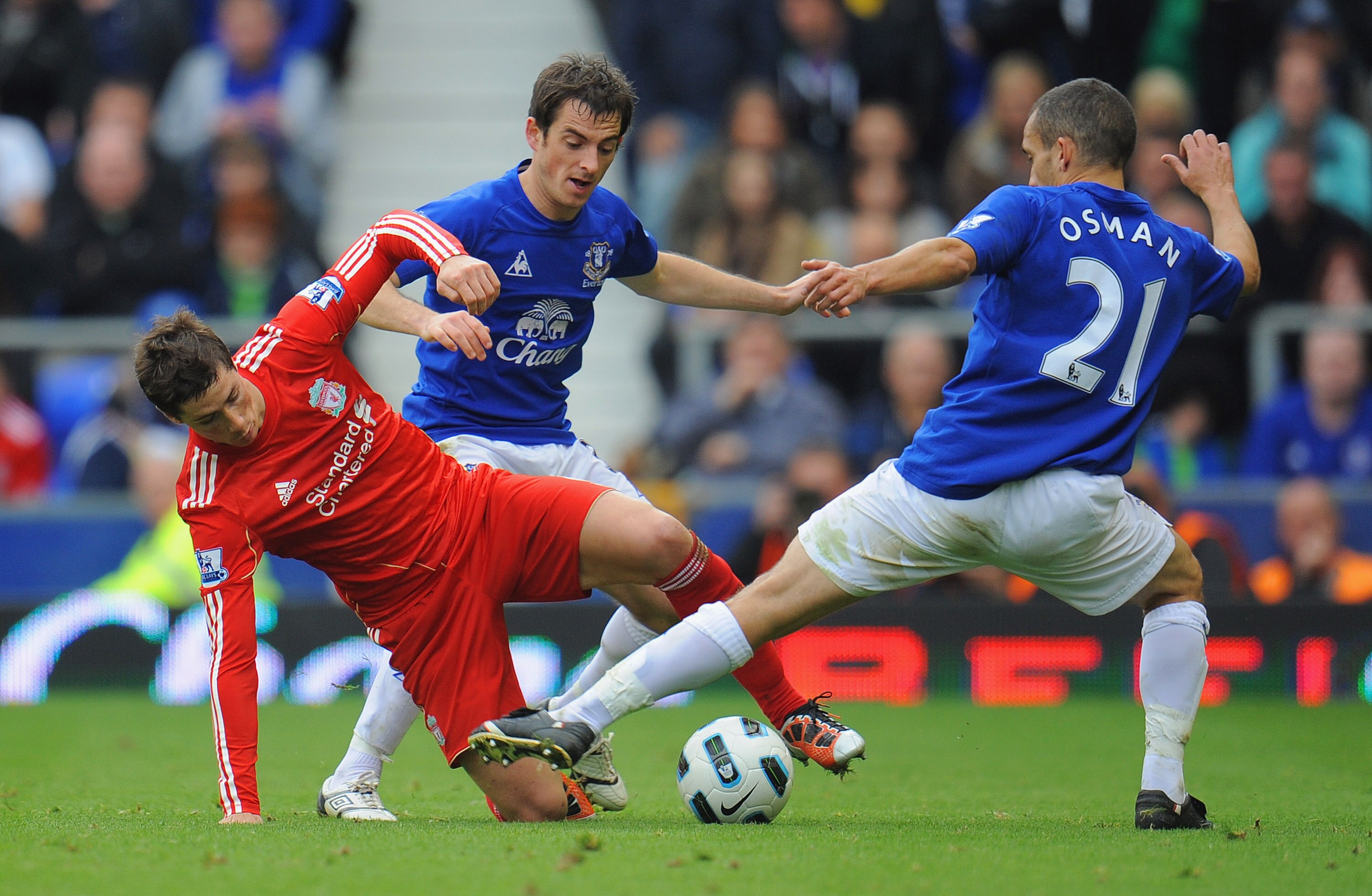 LIVERPOOL, ENGLAND - OCTOBER 17: Fernando Torres of Liverpool is tackled by Leighton Baines and Leon Osman of Everton during the Barclays Premier League match between Everton and Liverpool at Goodison Park on October 17, 2010 in Liverpool, England.  (Phot