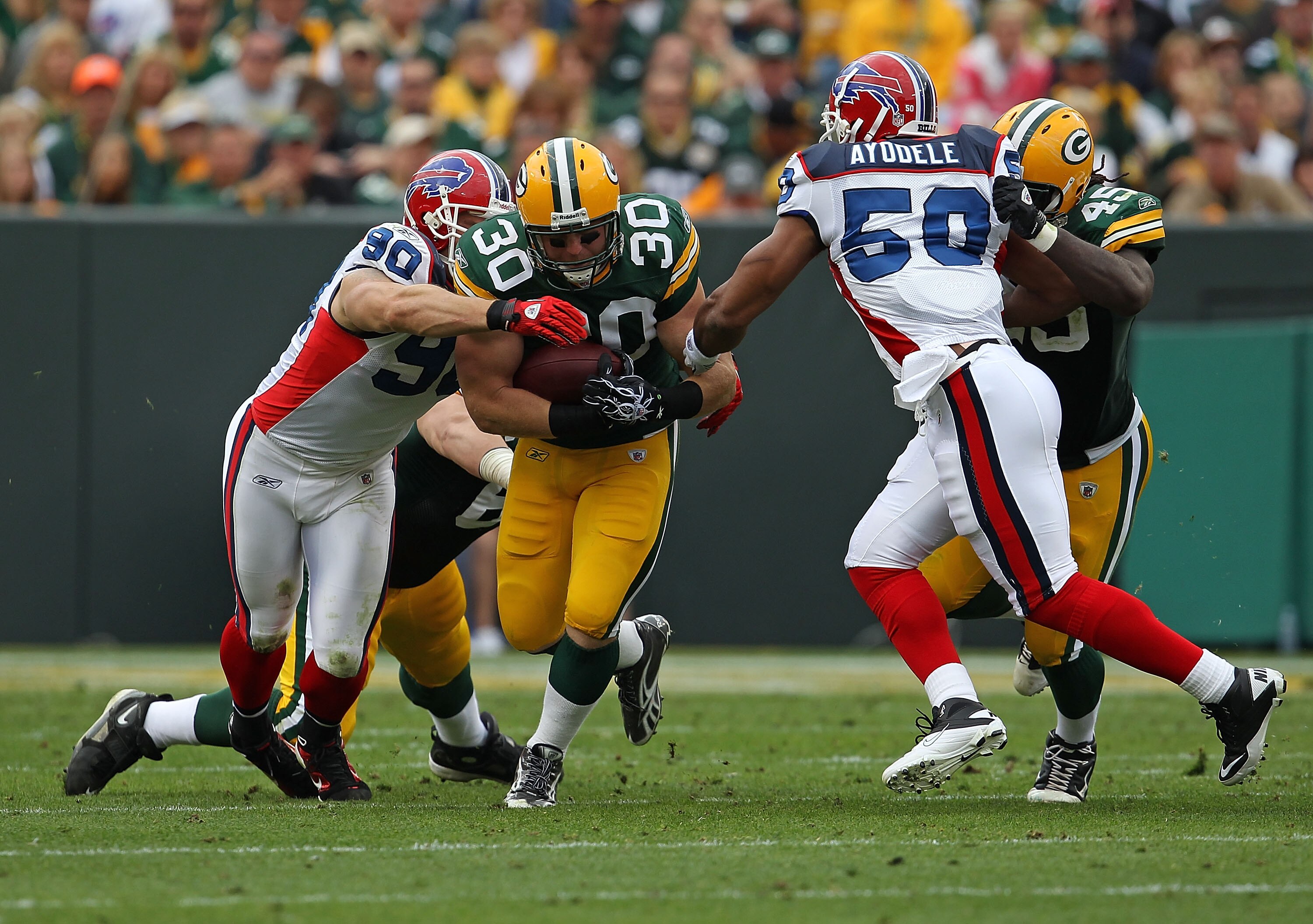 GREEN BAY, WI - SEPTEMBER 19: John Kuhn #30 of the Green Bay Packers runs between Chris Kelsay #90 and Akin Ayodele #50 of the Buffalo Bills at Lambeau Field on September 19, 2010 in Green Bay, Wisconsin. The Packers defeated the Bills 34-7.  (Photo by Jo