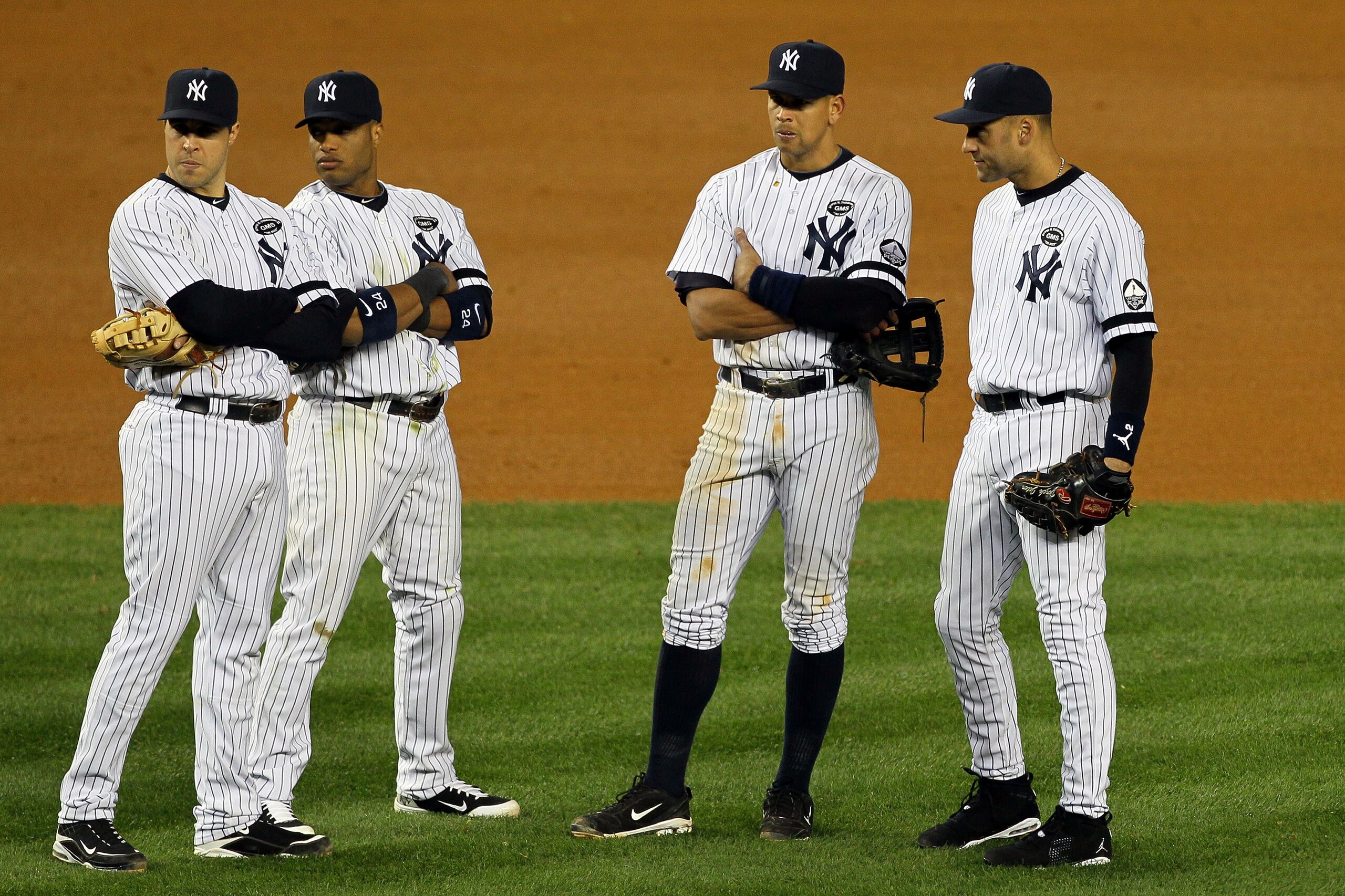 NEW YORK - OCTOBER 18: Mark Teixeira #25, Robinson Cano #24, Alex Rodriguez #13 and Derek Jeter #2 of the New York Yankees look on during a pitching change against the Texas Rangers in Game Three of the ALCS during the 2010 MLB Playoffs at Yankee Stadium NEW YORK - OCTOBER 18: Mark Teixeira #25, Robinson Cano #24, Alex Rodriguez #13 and Derek Jeter #2 of the New York Yankees look on during a pitching change against the Texas Rangers in Game Three of the ALCS during the 2010 MLB Playoffs at Yankee Stadium