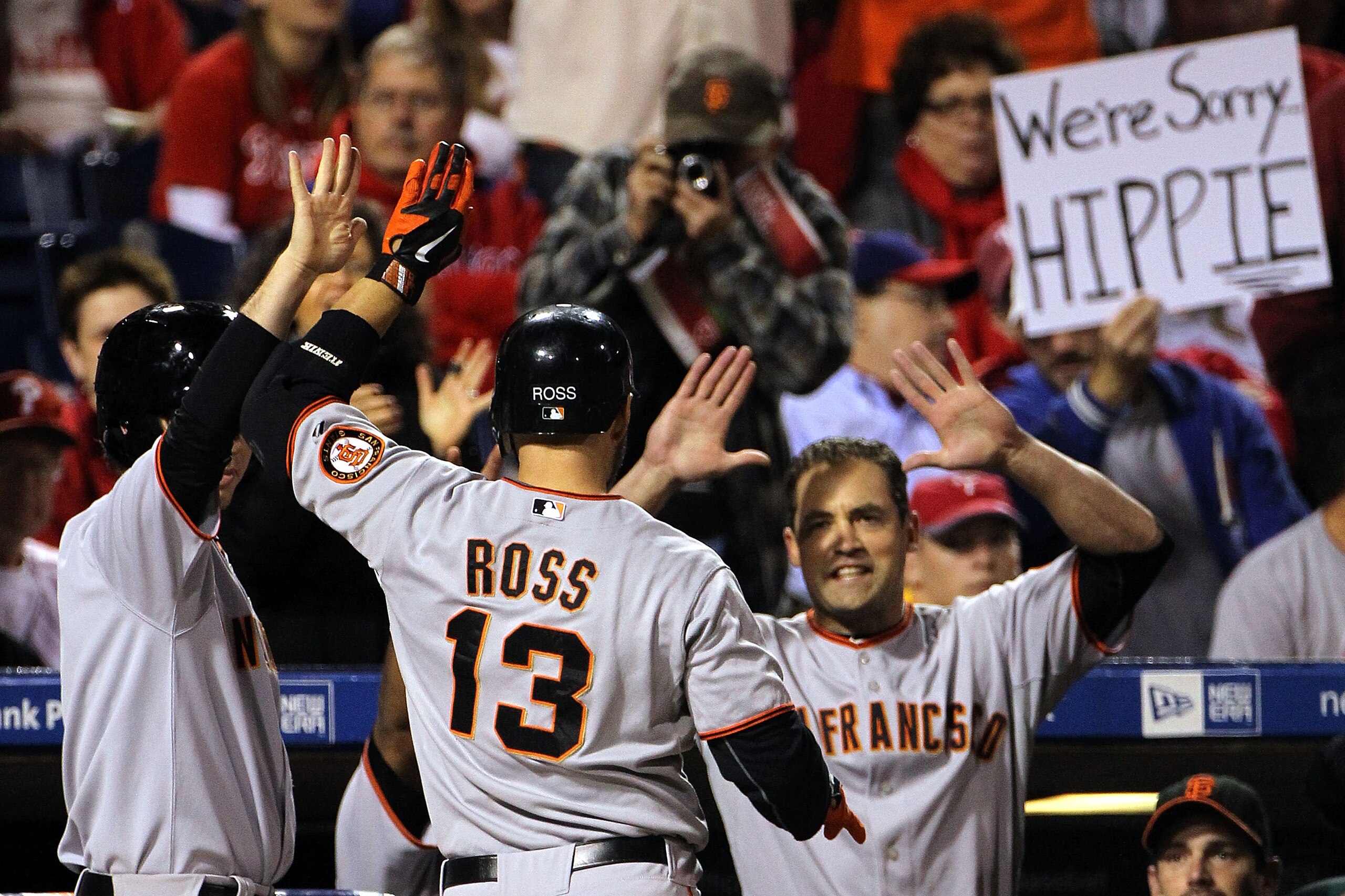 PHILADELPHIA - OCTOBER 17:  Cody Ross #13 of the San Francisco Giants is greeted at the dugout by his teammates after Ross hits a solo home run in the fifth inning against the Philadelphia Phillies in Game Two of the NLCS during the 2010 MLB Playoffs at C