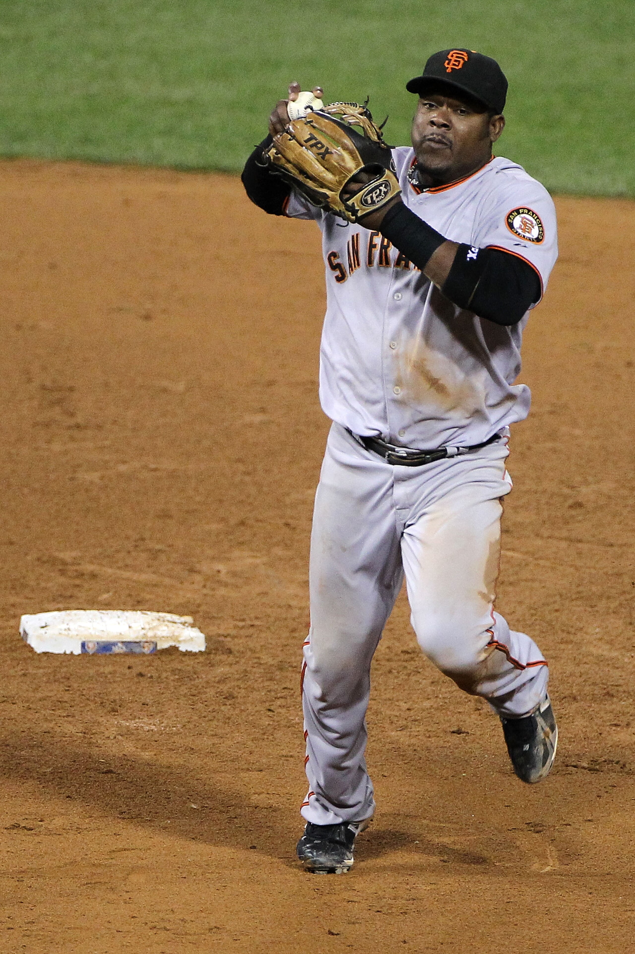 PHILADELPHIA - OCTOBER 16:  Juan Uribe #5 of the San Francisco Giants throws out Carlos Ruiz #51 of the Philadelphia Phillies at first base in the fourth inning of Game One of the NLCS during the 2010 MLB Playoffs at Citizens Bank Park on October 16, 2010