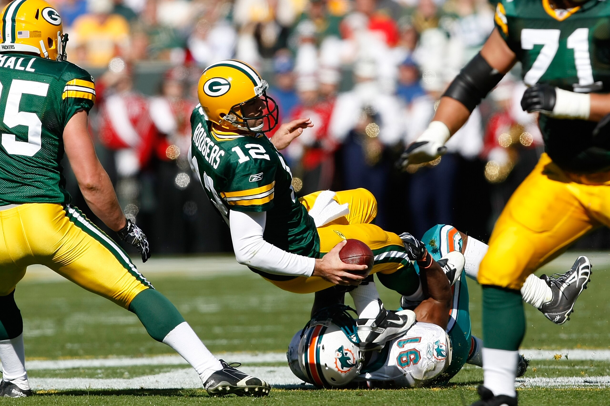 GREEN BAY, WI - OCTOBER 17: Aaron Rogers #12 of the Green Bay Packers is sacked by Cameron Wake #91 of the Miami Dolphins at Lambeau Field on October 17, 2010 in Green Bay, Wisconsin. (Photo by Scott Boehm/Getty Images)