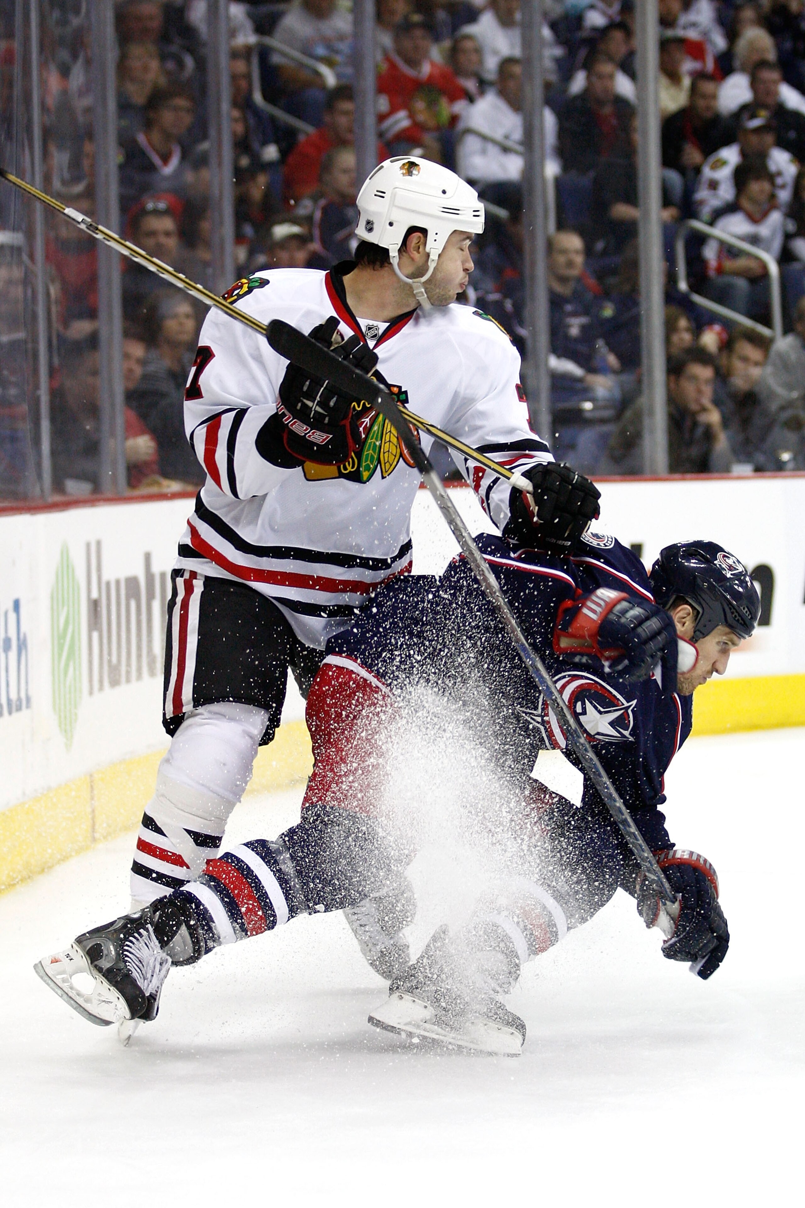 COLUMBUS,OH - October 15:   Brent Seabrook #7 of the Chicago Blackhawks checks Chris Clark #11 of the Columbus Blue Jackets while chasing down a loose puck during the second period on October 15, 2010 at Nationwide Arena in Columbus, Ohio.  (Photo by John