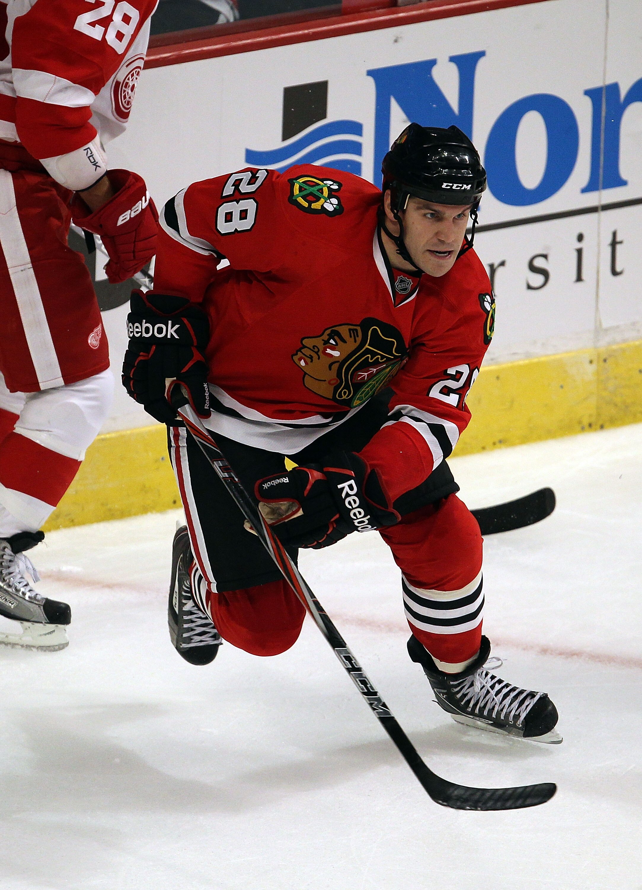 CHICAGO - OCTOBER 09: Jake Dowell #28 of the Chicago Blackhawks skates to the puck against the Detroit Red Wings during the Blackhawks season home opening game at the United Center on October 9, 2010 in Chicago, Illinois. The Red Wings defeated the Blackh