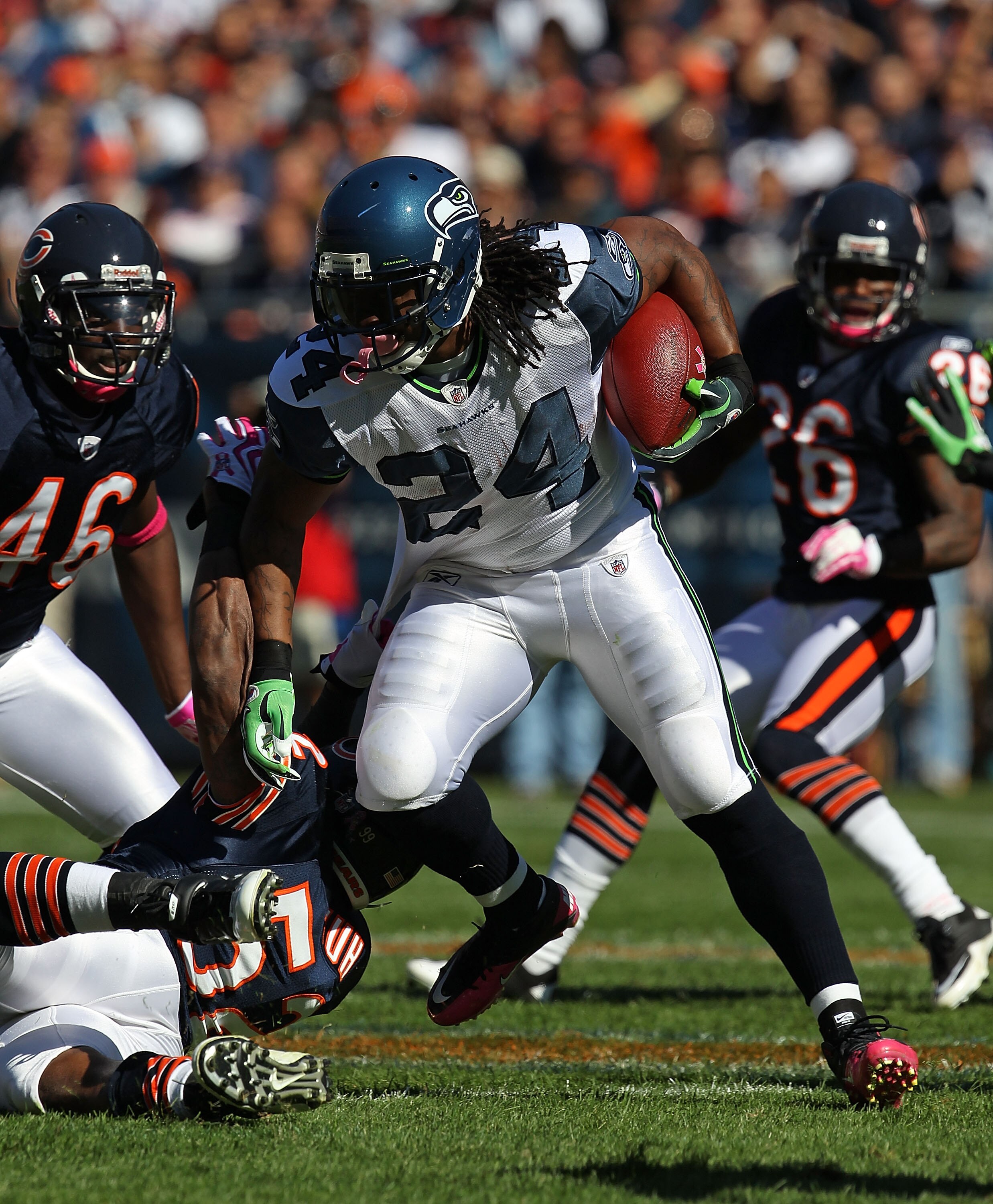 CHICAGO - OCTOBER 17: Marshawn Lynch #24 of the Seattle Seahawks runs past Brian Iwuh #52 and Chris Harris #46 of the Chicago Bears at Soldier Field on October 17, 2010 in Chicago, Illinois. The Seahawks defeated the Bears 23-20. (Photo by Jonathan Daniel