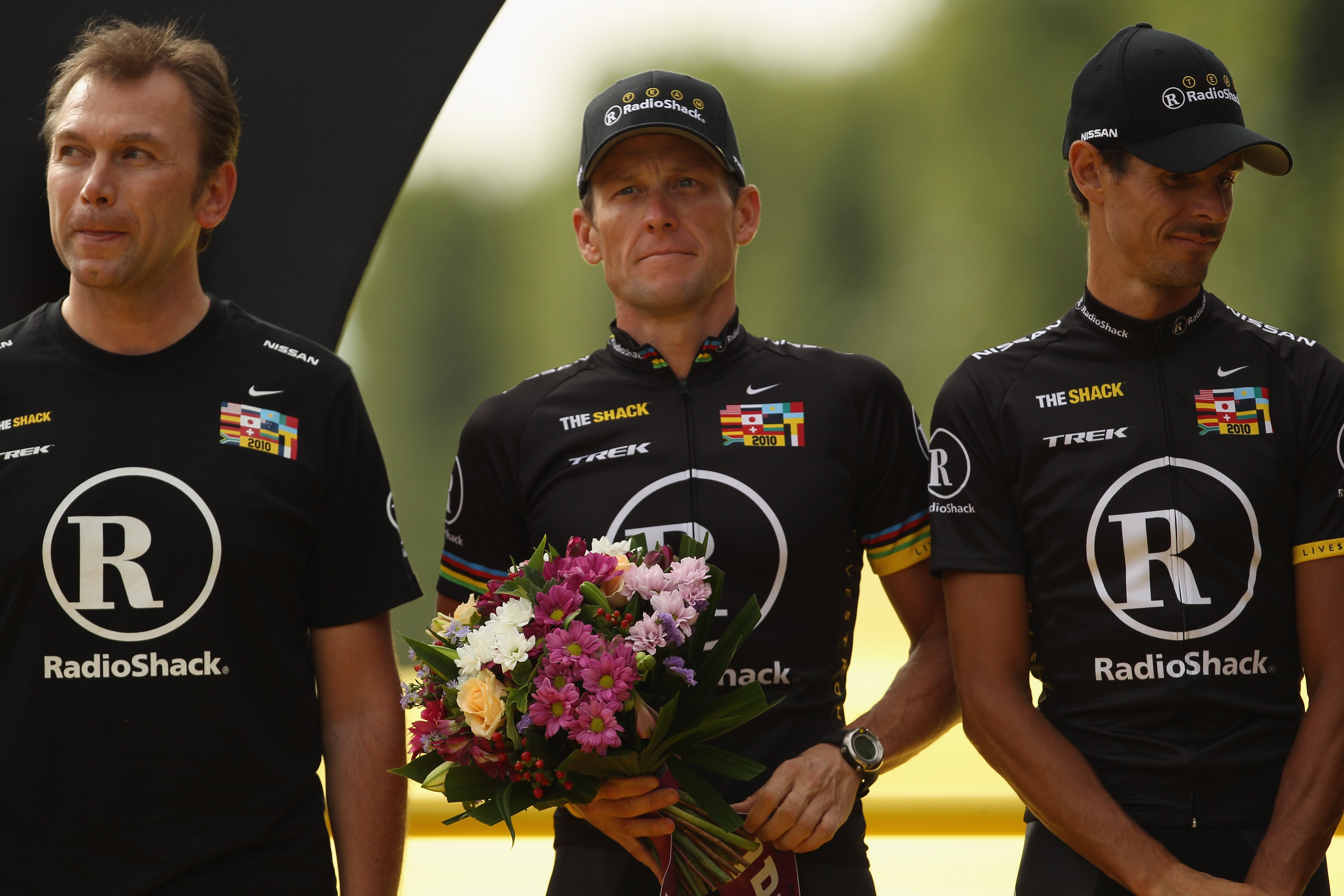 PARIS - JULY 25:  Johan Brunyeel (L), Lance Armstrong and Andreas Kloden of team Radioshack stand on the podium to receive the Team Classification award after the twentieth and final stage of Le Tour de France 2010, from Longjumeau to the Champs-Elysees i