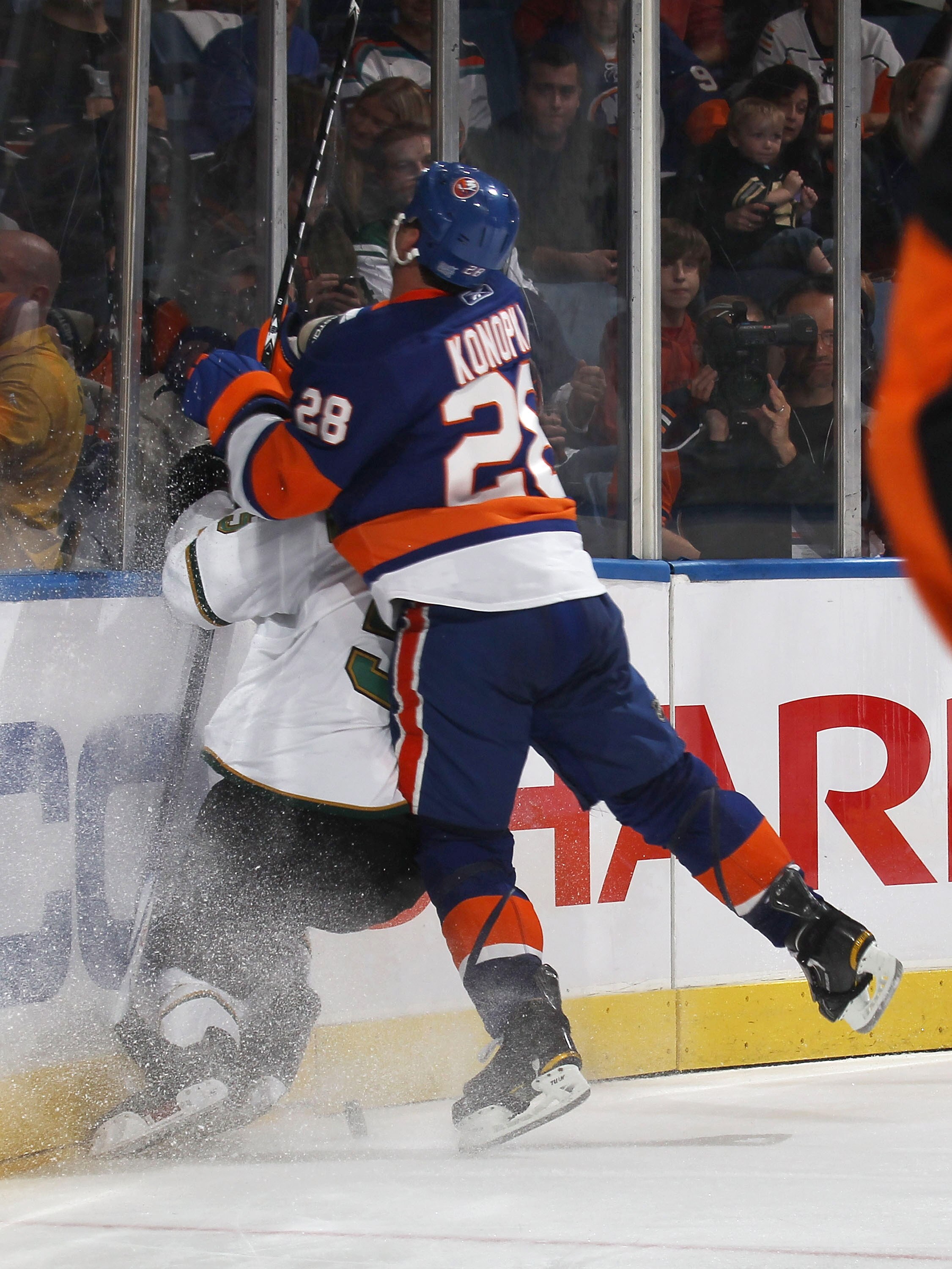 UNIONDALE, NY - OCTOBER 09:  Zenon Konopka #28 of the New York Islanders checks a Dallas Star in a game at the Nassau Coliseum on October 9, 2010 in Uniondale, New York.  (Photo by Bruce Bennett/Getty Images)