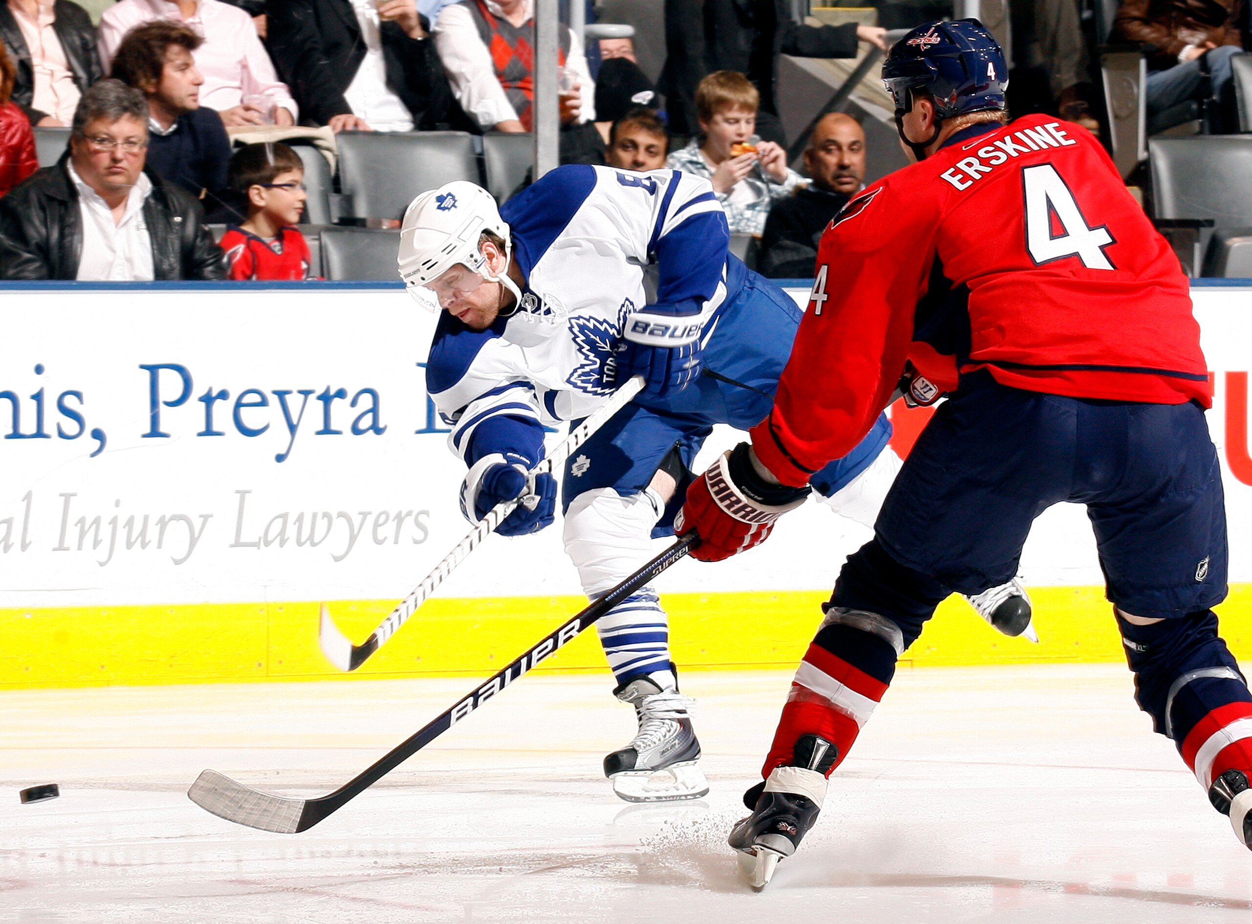 TORONTO - NOVEMBER 21:  Phil Kessel #81 of the Toronto Maple Leafs shoots past John Erskine #4 of the Washington Capitals during game action November 21, 2009 at the Air Canada Centre in Toronto, Ontario, Canada. (Photo by Abelimages/Getty Images)