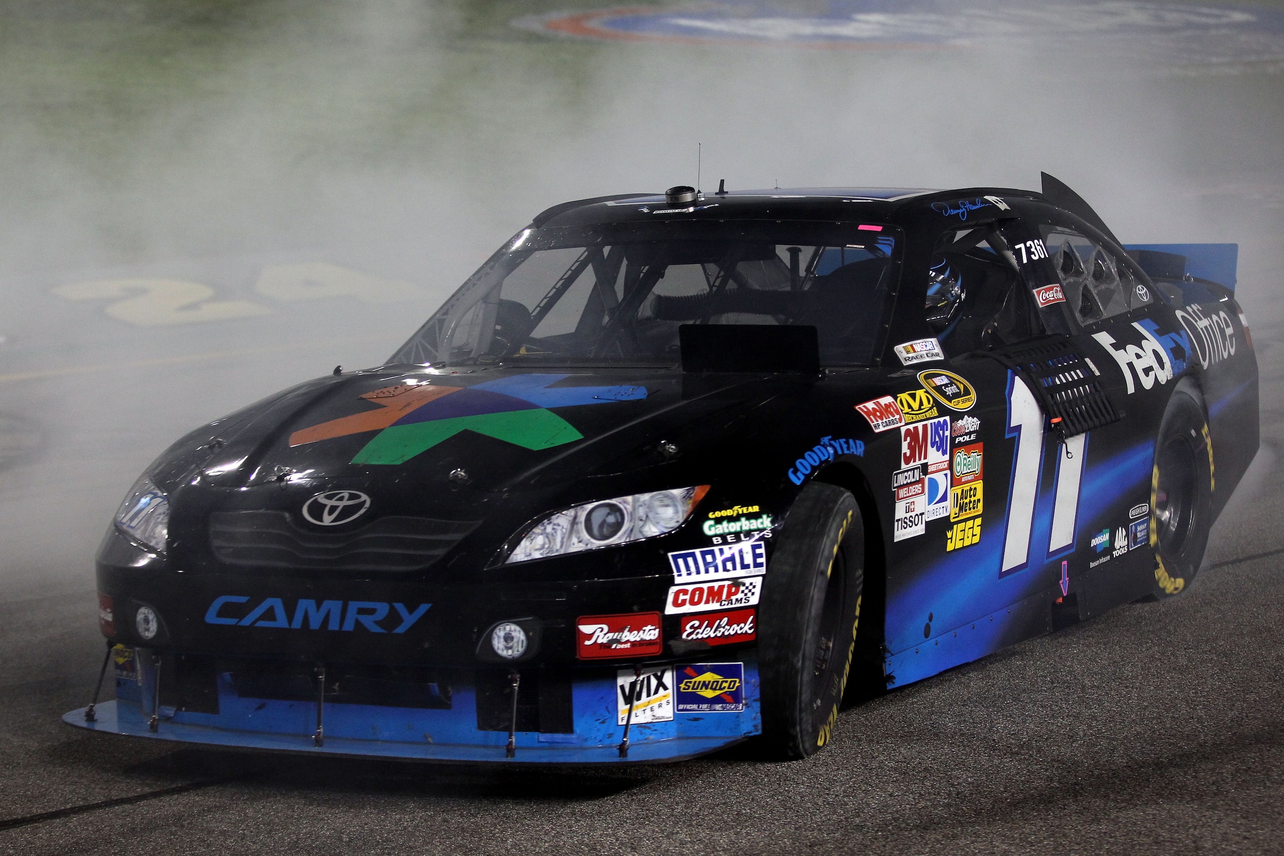 RICHMOND, VA - SEPTEMBER 11:  Denny Hamlin, driver of the #11 FedEx Office Toyota, performs a burnout to celebrate winning the NASCAR Sprint Cup Series Air Guard 400 at Richmond International Raceway on September 11, 2010 in Richmond, Virginia.  (Photo by