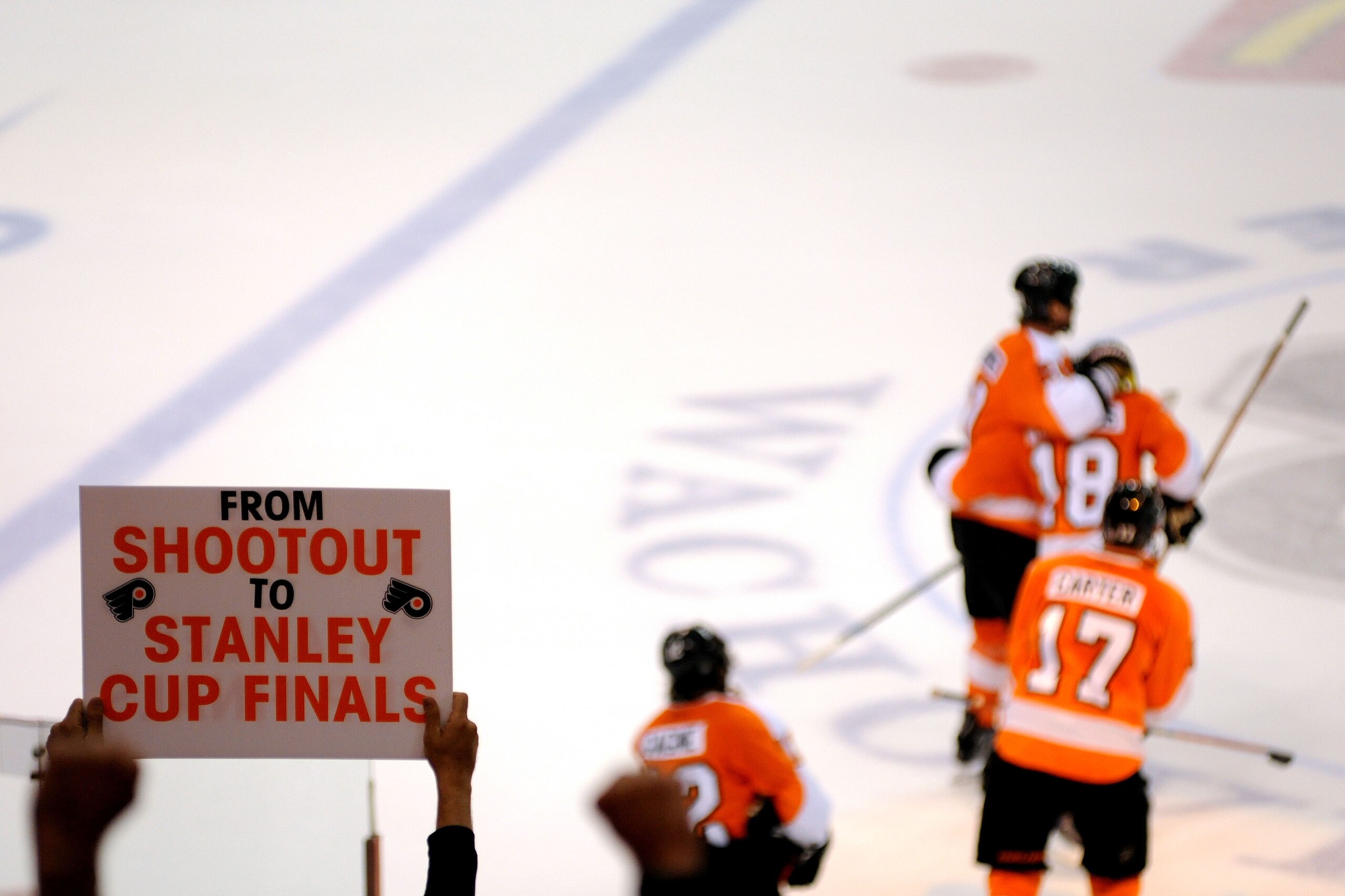 PHILADELPHIA - MAY 24:  A fan holds up a sign reading 'From Shootout to Stanley Cup Finals as the Philadelphia Flyers celebrate on the ice after an empty net goal in the third period against the Montreal Canadiens in Game 5 of the Eastern Conference Final