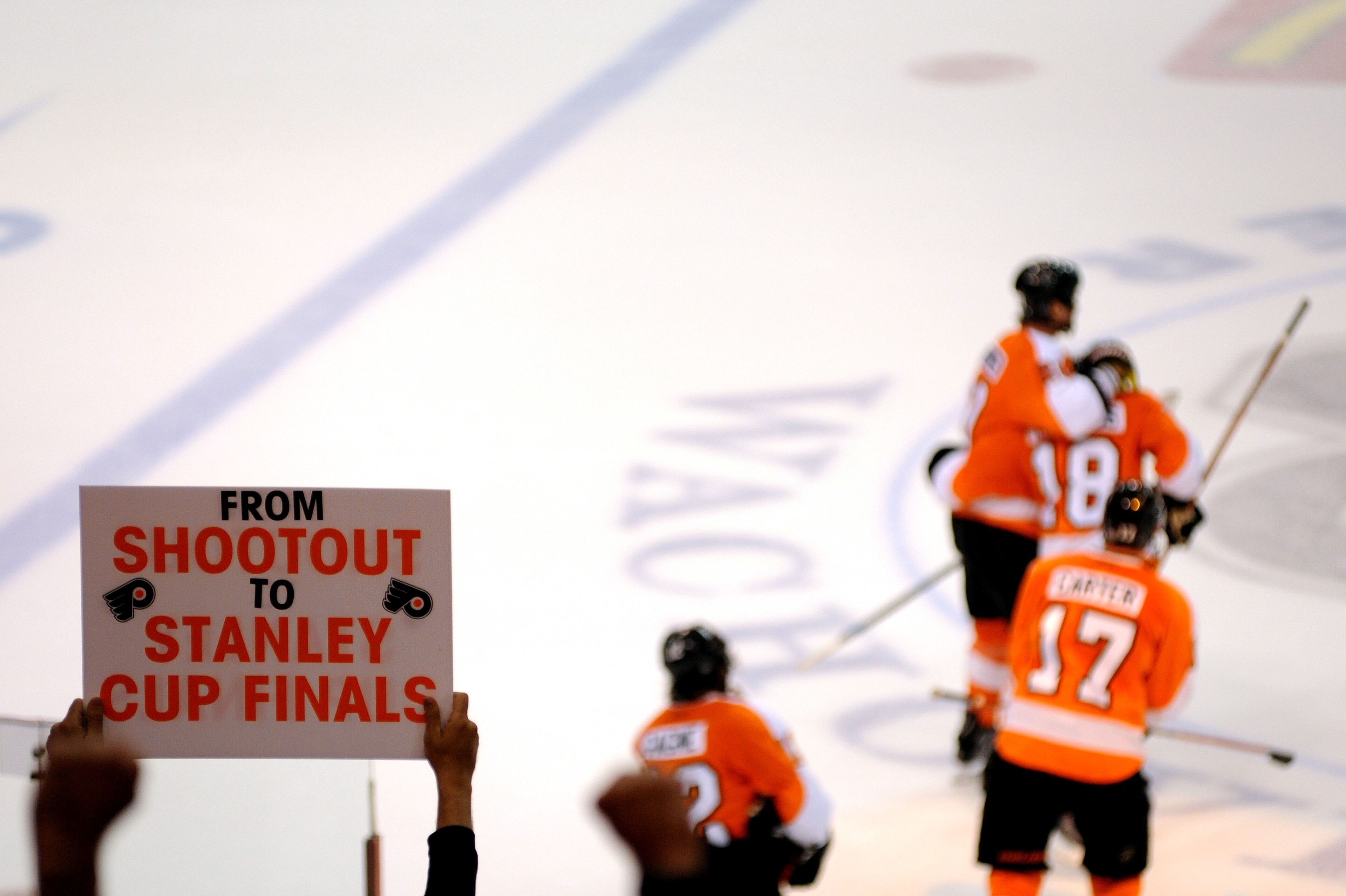 PHILADELPHIA - MAY 24:  A fan holds up a sign reading 'From Shootout to Stanley Cup Finals as the Philadelphia Flyers celebrate on the ice after an empty net goal in the third period against the Montreal Canadiens in Game 5 of the Eastern Conference Final