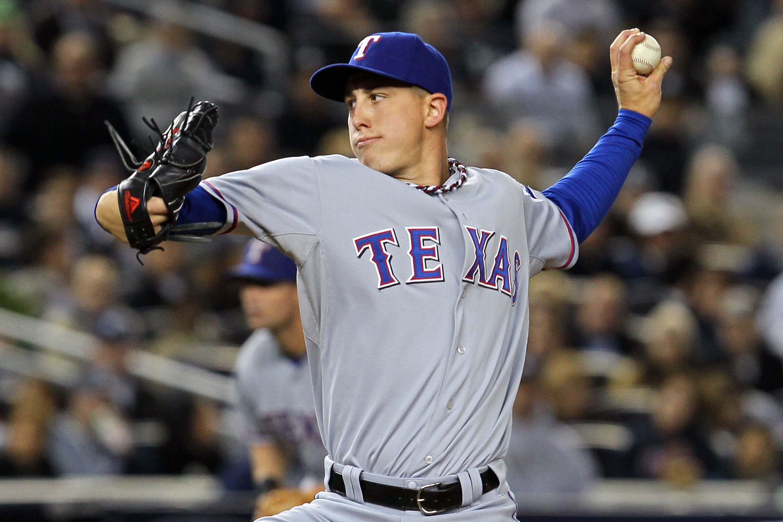 NEW YORK - OCTOBER 19:  Derek Holland #45 of the Texas Rangers pitches against the New York Yankees in Game Four of the ALCS during the 2010 MLB Playoffs at Yankee Stadium on October 19, 2010 in the Bronx borough of New York City.  (Photo by Jim McIsaac/G