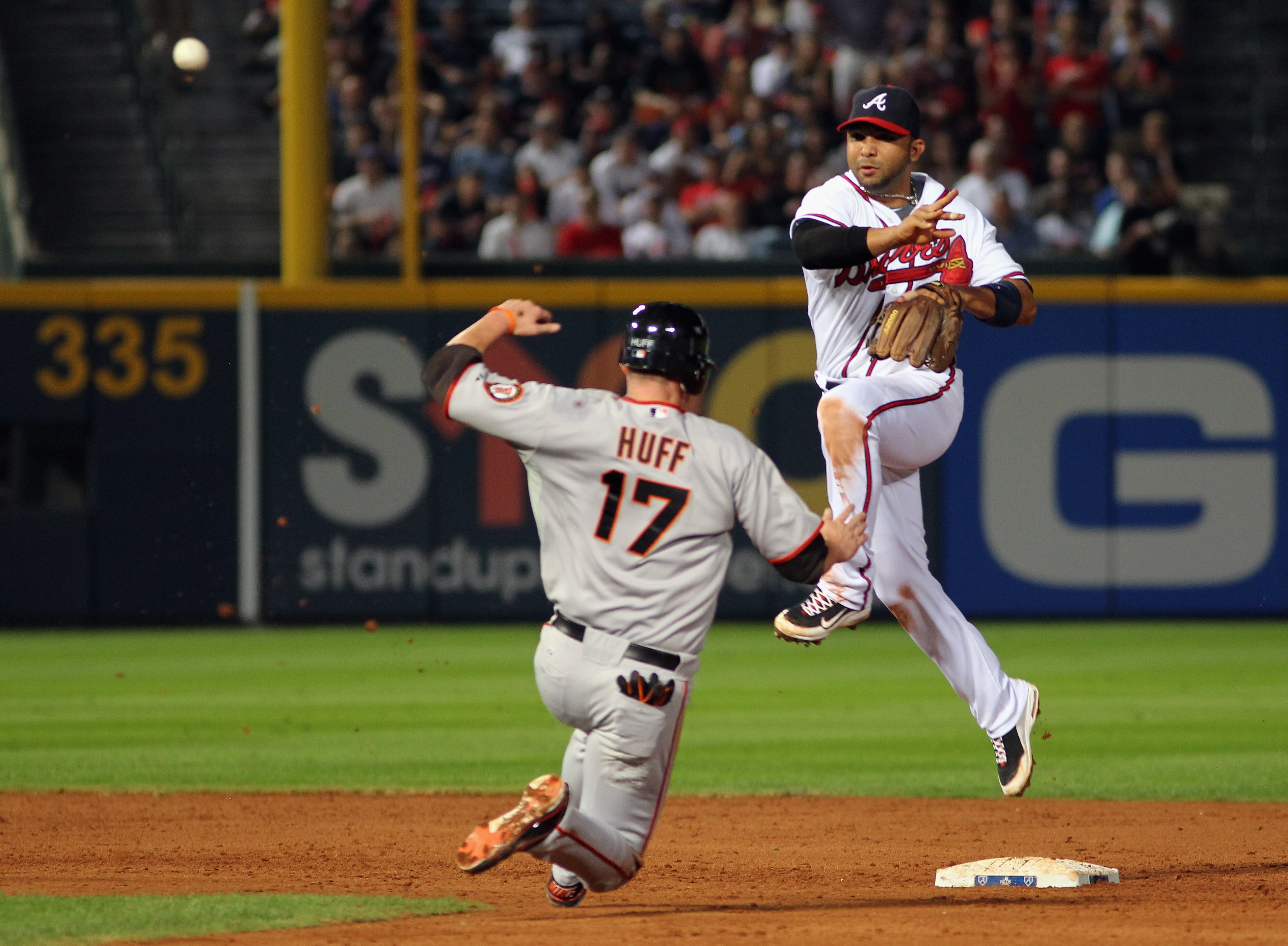 ATLANTA - OCTOBER 11:  Shortstop Alex Gonzalez #2 of the Atlanta Braves turns a double play as Aubrey Huff #17 of the San Francisco Giants approaches second during the 9th inning of Game Four of the NLDS of the 2010 MLB Playoffs on October 11, 2010  at Tu