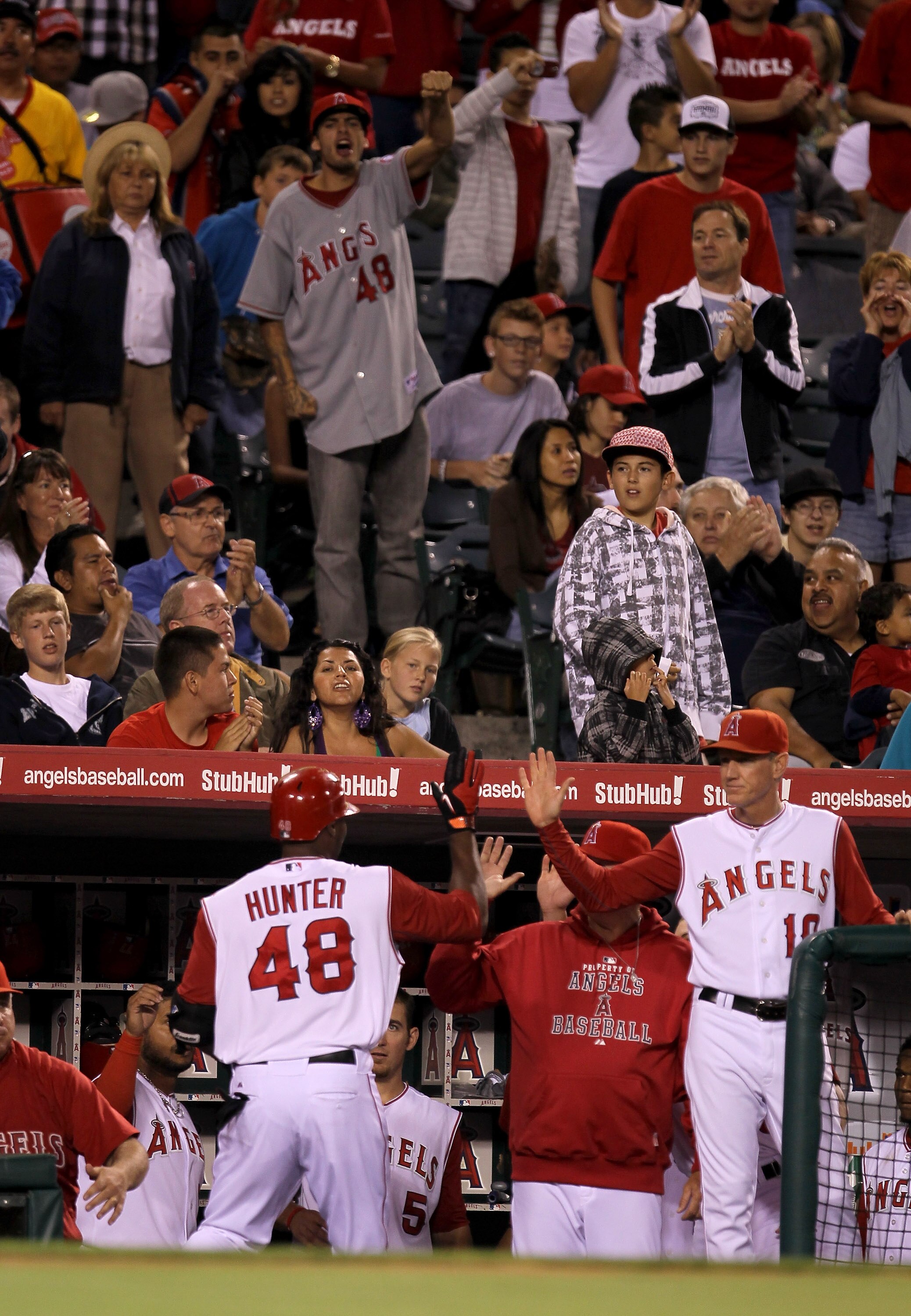 ANAHEIM, CA - SEPTEMBER 6:  Torii Hunter #48 of the Los Angeles Angels of Anaheim is greeted by teammates and fans as he returns to the dugout after hitting a game tying home run in the sixth inning against the Cleveland Indians on September 6, 2010 at An