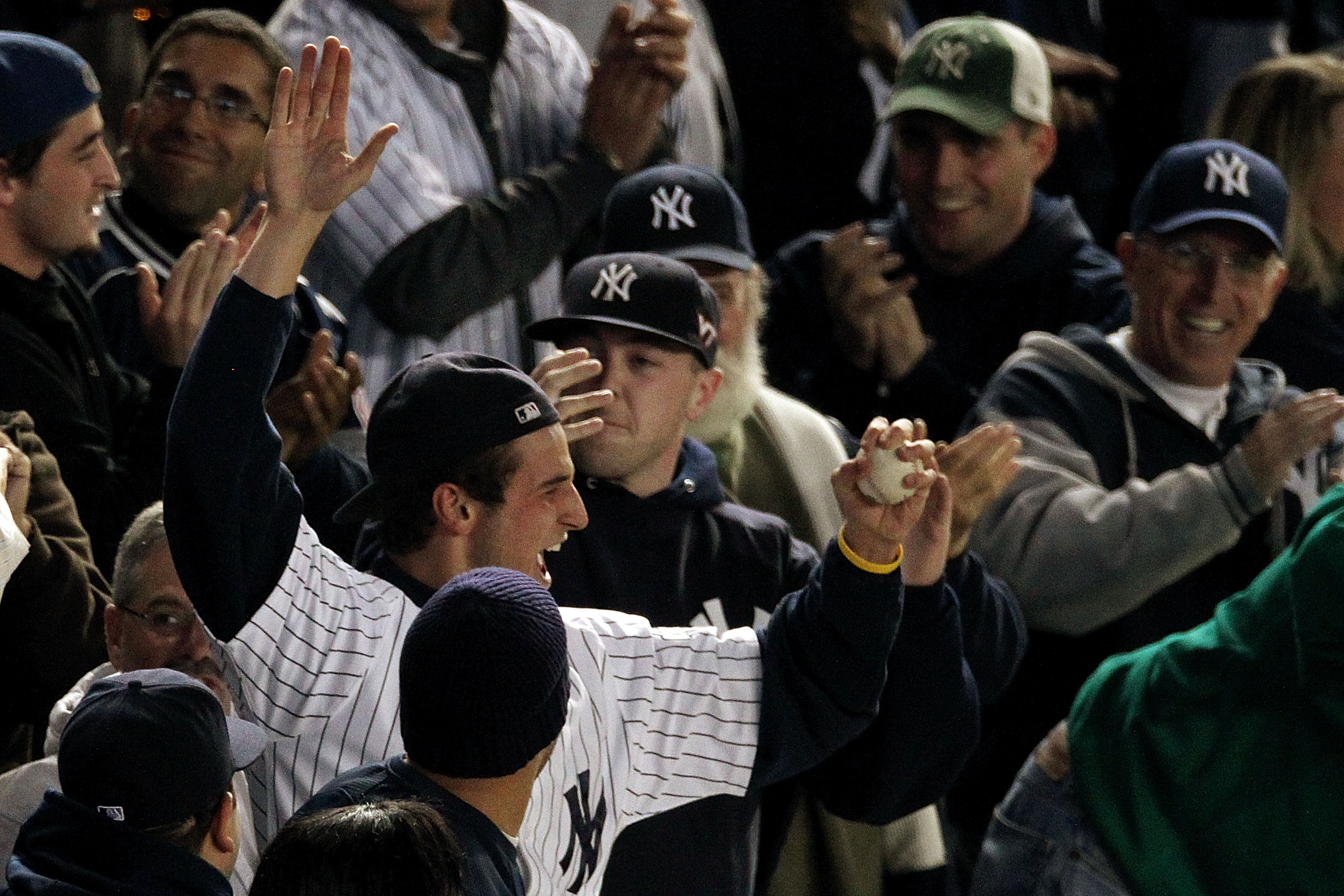 NEW YORK - OCTOBER 19:  A fan of the New York Yankees reacts after he caught a home run ball hit by Robinson Cano #24 of the Yankees in the bottom of the seocnd inning against the Texas Rangers in Game Four of the ALCS during the 2010 MLB Playoffs at Yank