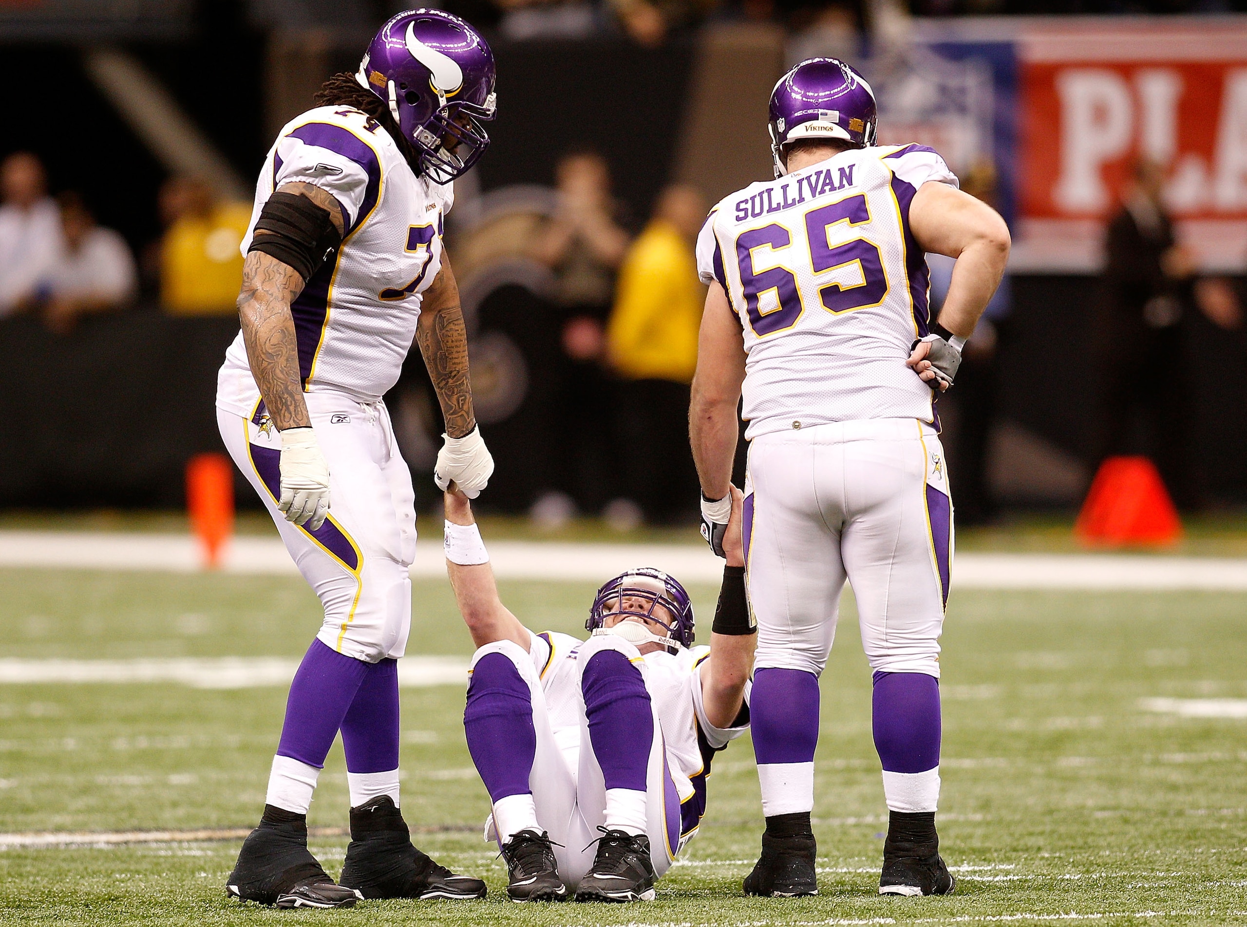 NEW ORLEANS - JANUARY 24:  Brett Favre #4 of  the Minnesota Vikings is helped up by teammates Phil Loadholt #71 and John Sullivan #65 after he took a hard hit in the second half against the New Orleans Saints during the NFC Championship Game at the Louisi