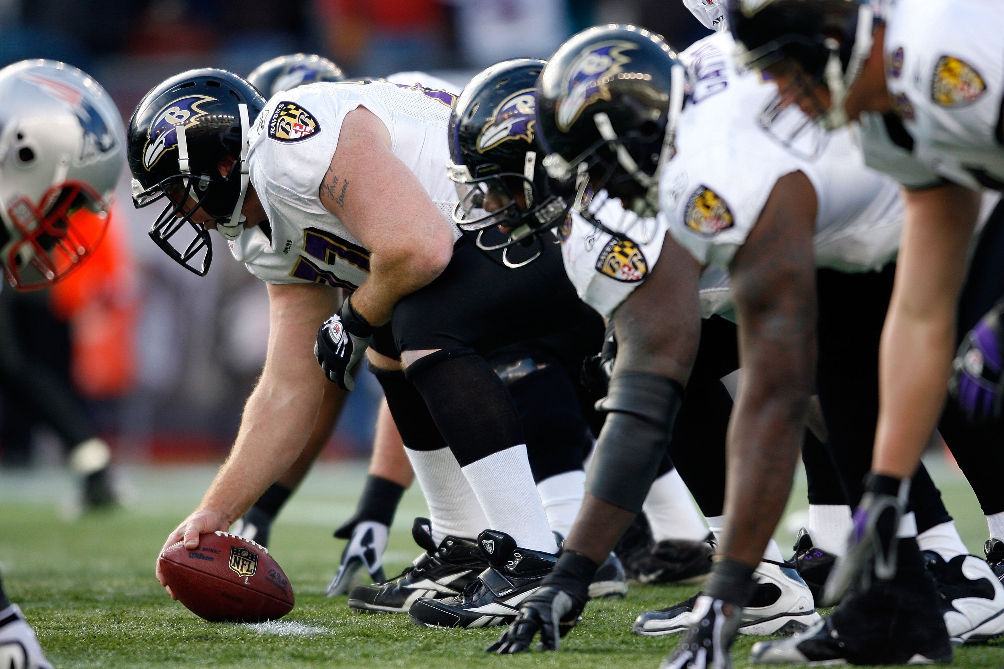 FOXBORO, MA - JANUARY 10:  Matt Birk #77 of the Baltimore Ravens centers the ball against the New England Patriots during the 2010 AFC wild-card playoff game at Gillette Stadium on January 10, 2010 in Foxboro, Massachusetts.  (Photo by Elsa/Getty Images)