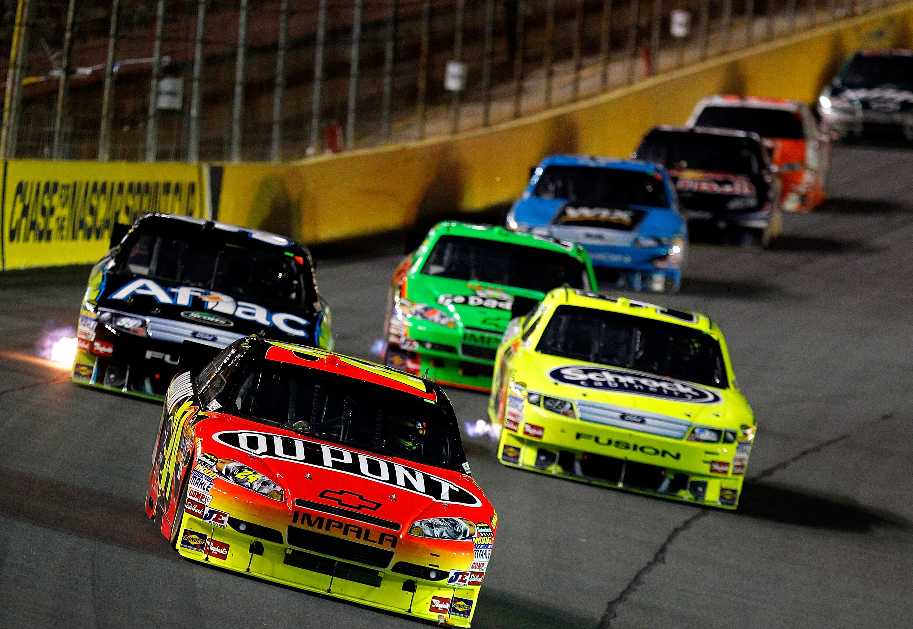 CONCORD, NC - OCTOBER 16: Jeff Gordon, driver of the #24 DuPont Chevrolet, leads Carl Edwards, driver of the #99 AFLAC Ford and Paul Menard, driver of the #98 Menards/Schrock Ford and others during the NASCAR Sprint Cup Series Bank of America 500 at Charl