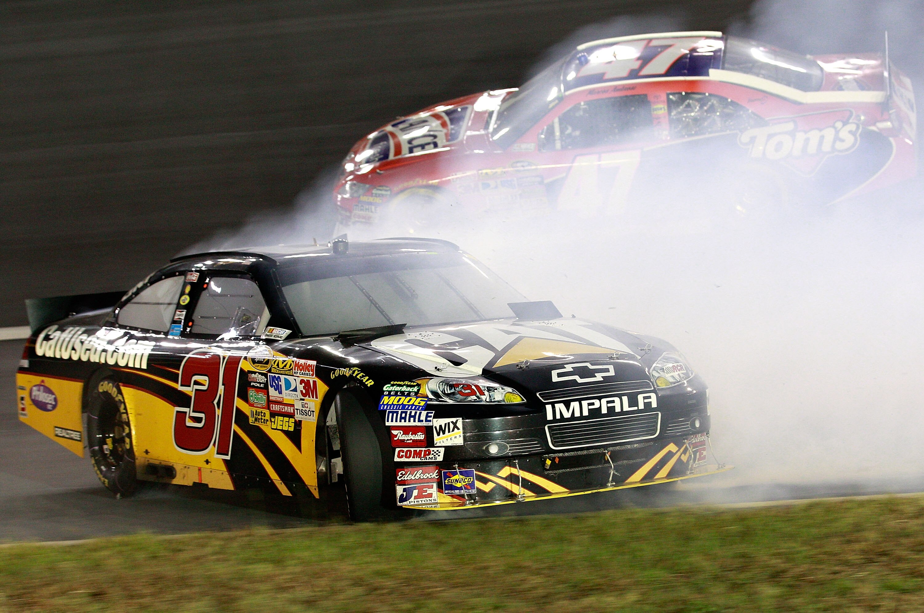 CONCORD, NC - OCTOBER 16:  Jeff Burton, driver of the #31 Caterpilliar Chevrolet, spins out in front of Marcos Ambrose, driver of the #47 Lance/Tom's Toyota, after an incident in the NASCAR Sprint Cup Series Bank of America 500 at Charlotte Motor Speedway