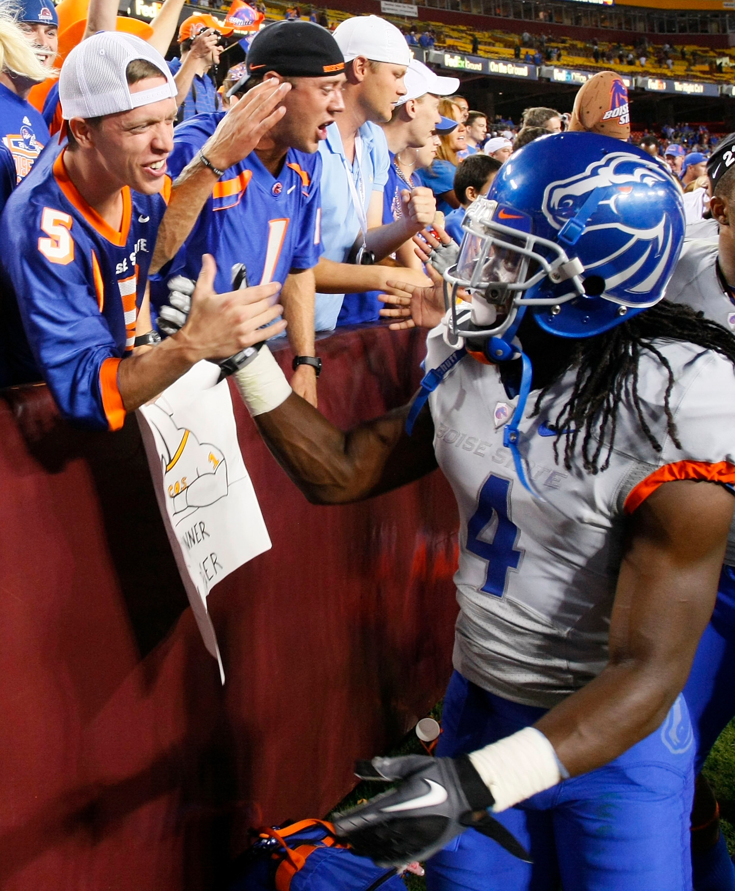 LANDOVER, MD - SEPTEMBER 06:  Defensive back Jerrell Gavins #4 of the Boise State Broncos shakes hands with a fan in the stands after the Broncos defeated the Virginia Tech Hokies 33-30  at FedExField on September 6, 2010 in Landover, Maryland.  (Photo by