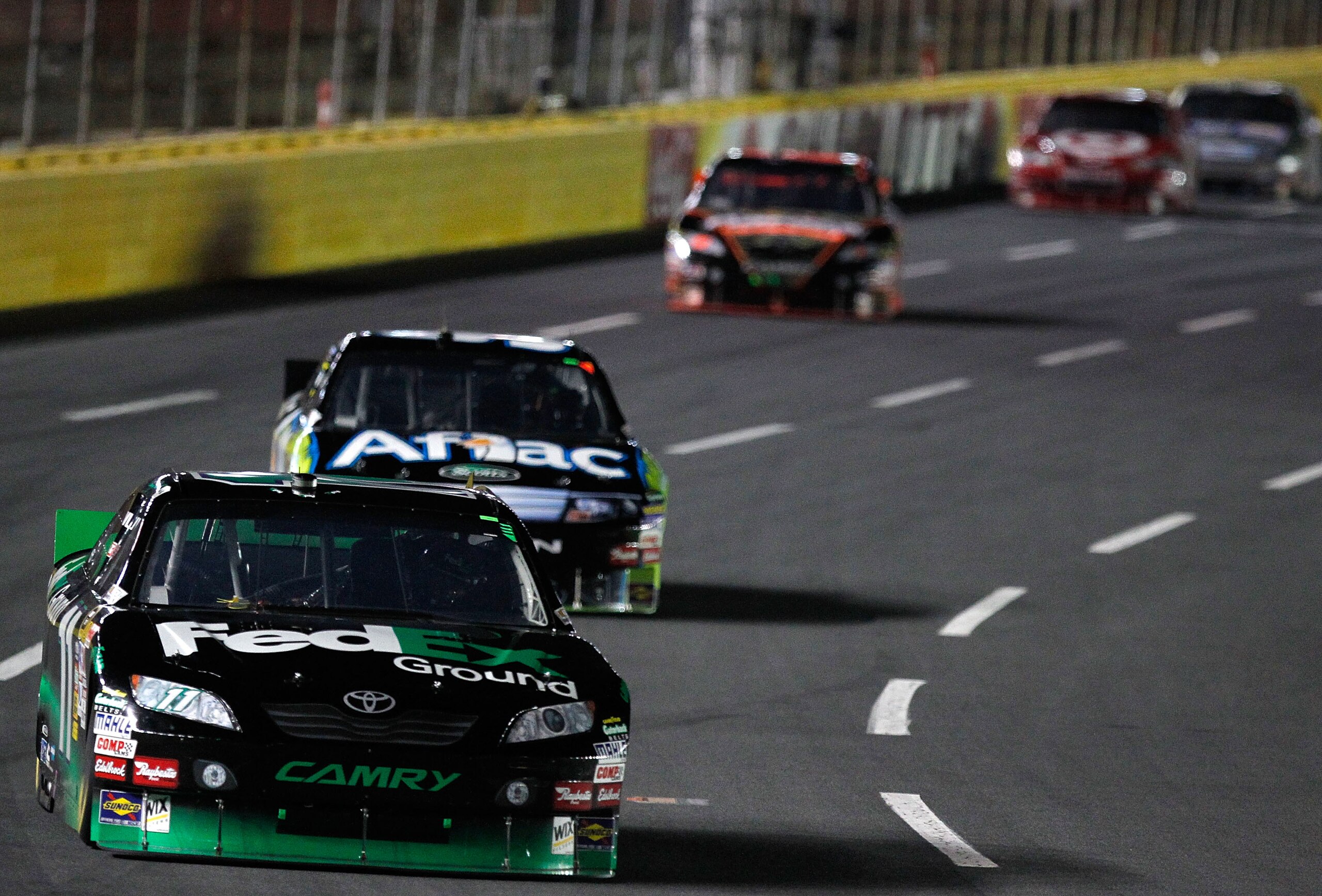 CONCORD, NC - OCTOBER 16:  Denny Hamlin, driver of the #11 FedEx Ground Toyota, races Carl Edwards, driver of the #99 Aflac Ford, during the NASCAR Sprint Cup Series Bank of America 500 at Charlotte Motor Speedway on October 16, 2010 in Concord, North Car