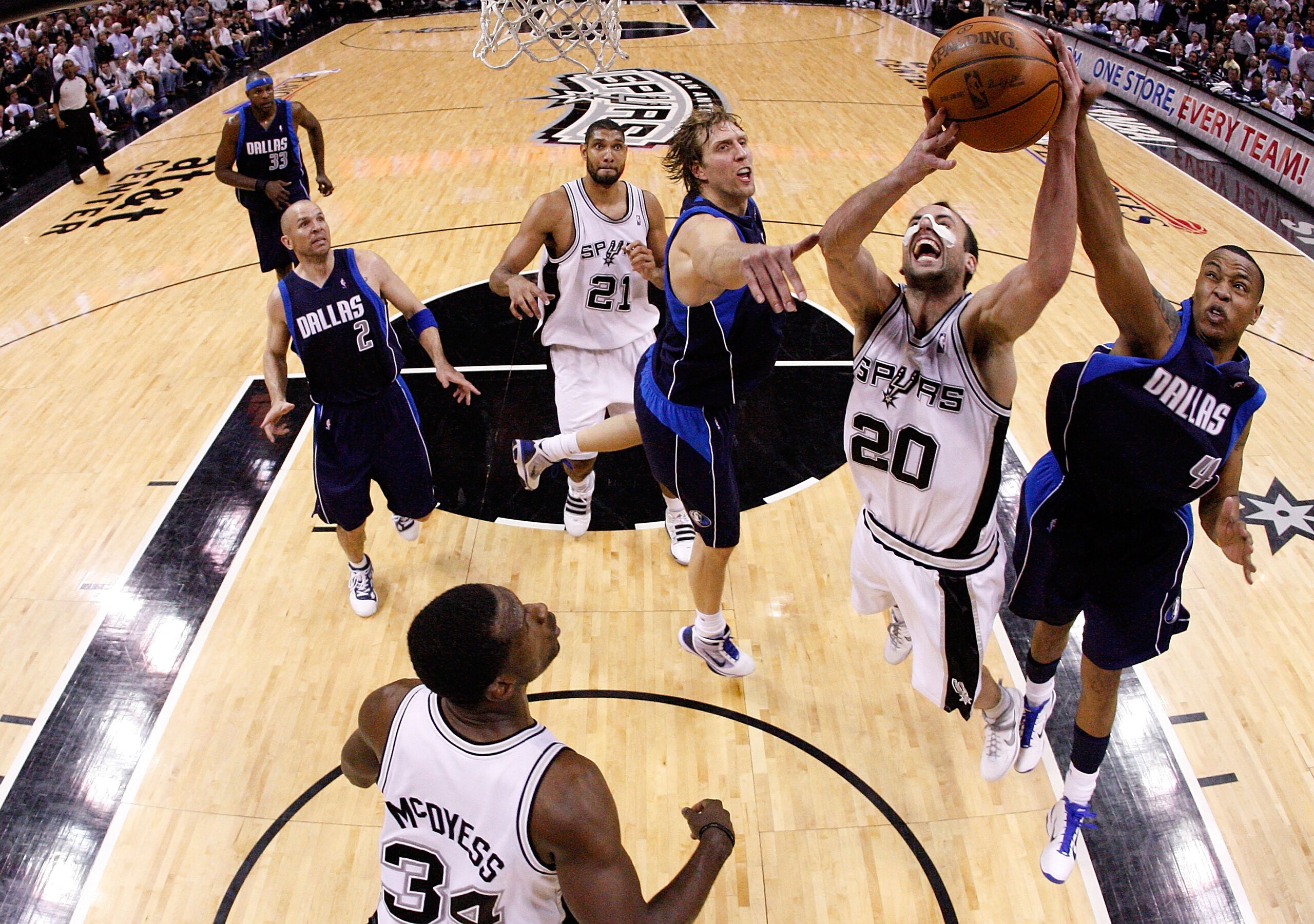 SAN ANTONIO - APRIL 29:  Guard Manu Ginobili #20 of the San Antonio Spurs takes a shot against Caron Butler #4 and Dirk Nowitzki #41 in Game Six of the Western Conference Quarterfinals during the 2010 NBA Playoffs at AT&T Center on April 29, 2010 in San A