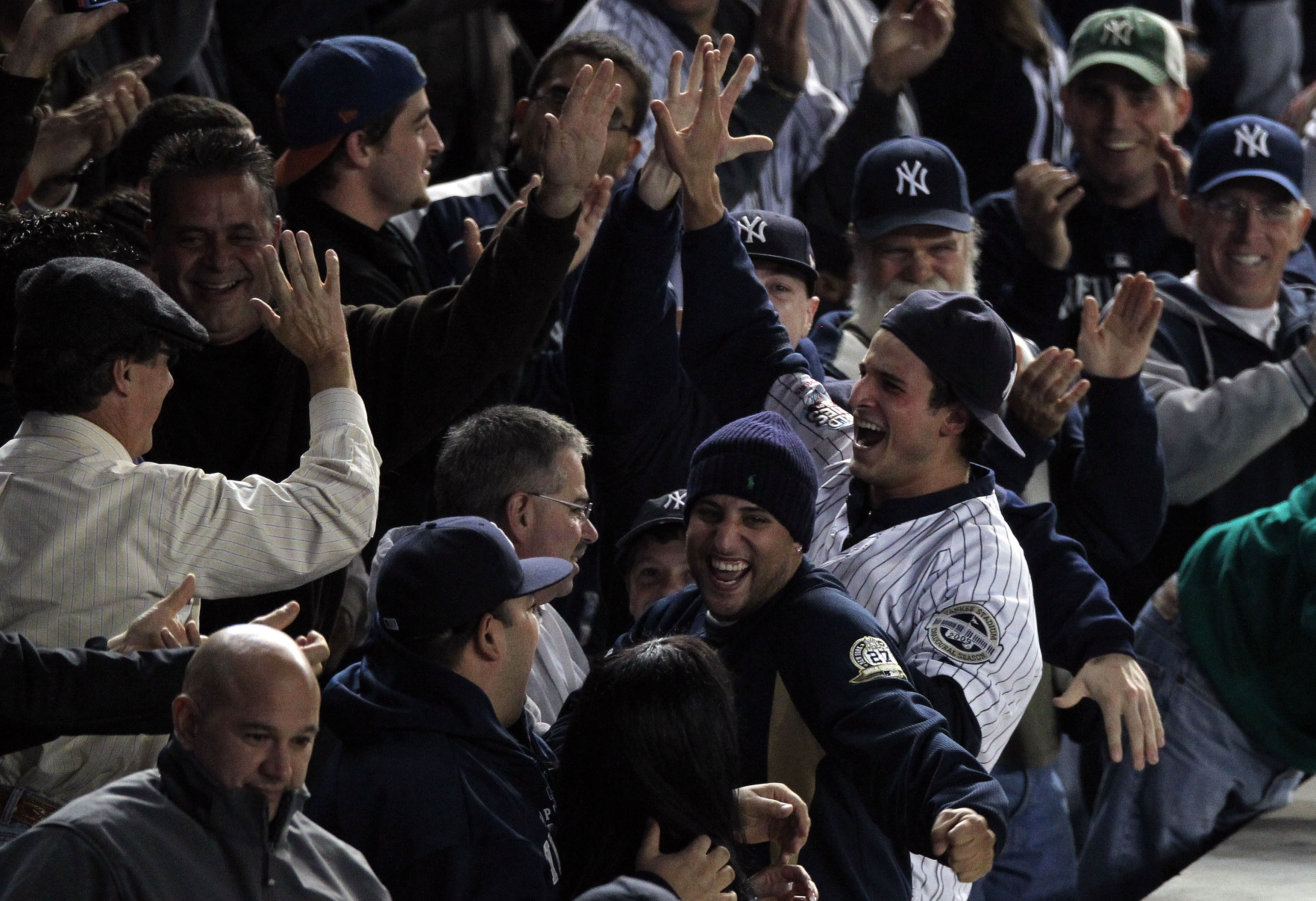 NEW YORK - OCTOBER 19:  A fan (R) of the New York Yankees reacts after he caught a home run ball hit by Robinson Cano #24 of the Yankees in the bottom of the seocnd inning against the Texas Rangers in Game Four of the ALCS during the 2010 MLB Playoffs at