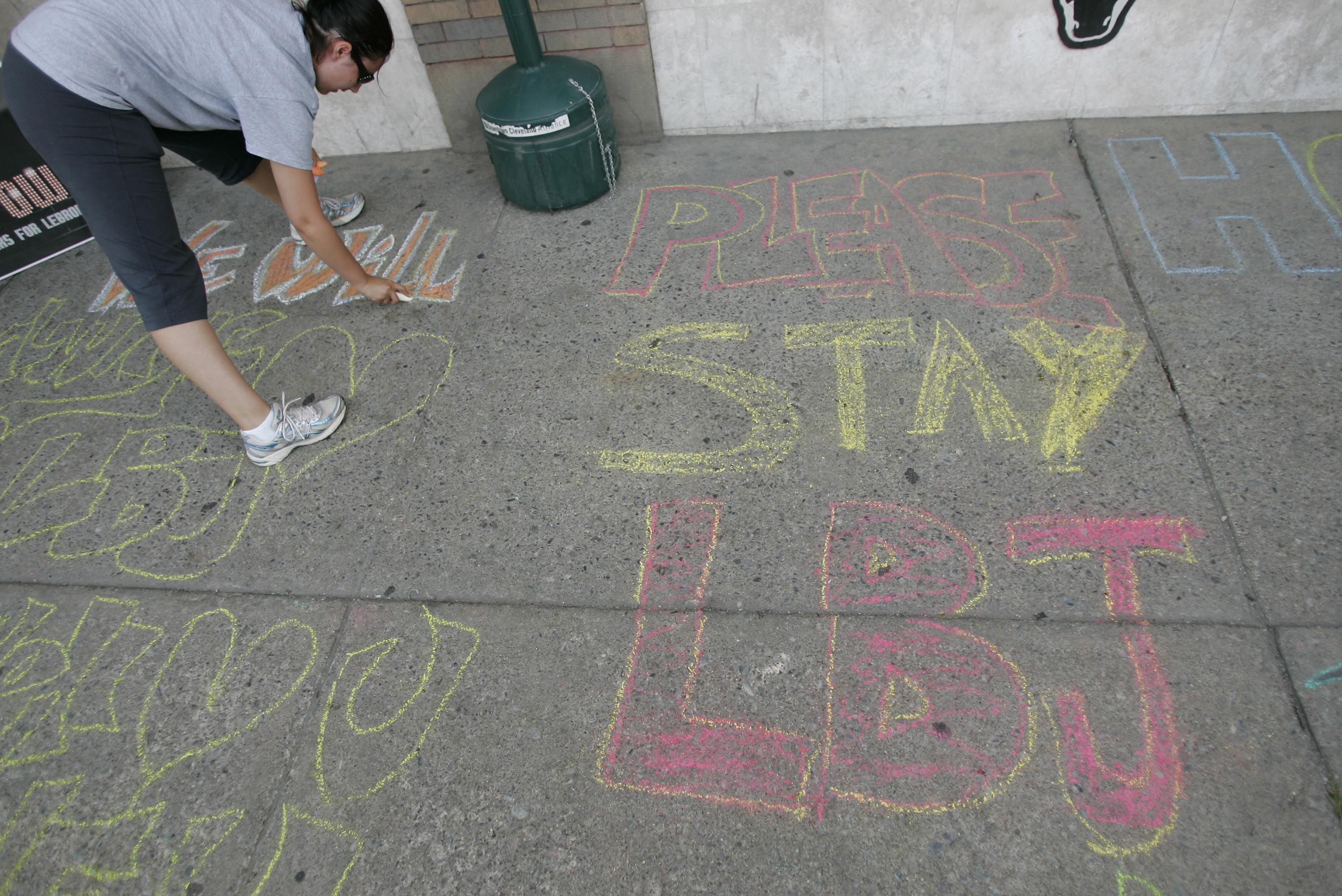 CLEVELAND - JULY 8:  Selina Rivera writes with chalk on a sidewalk outside a bar before the LeBron James Television Special July 8, 2010 in Cleveland, Ohio. The two-time Most Valuable Player has the choice of remaining with the Cleveland Cavaliers or sign