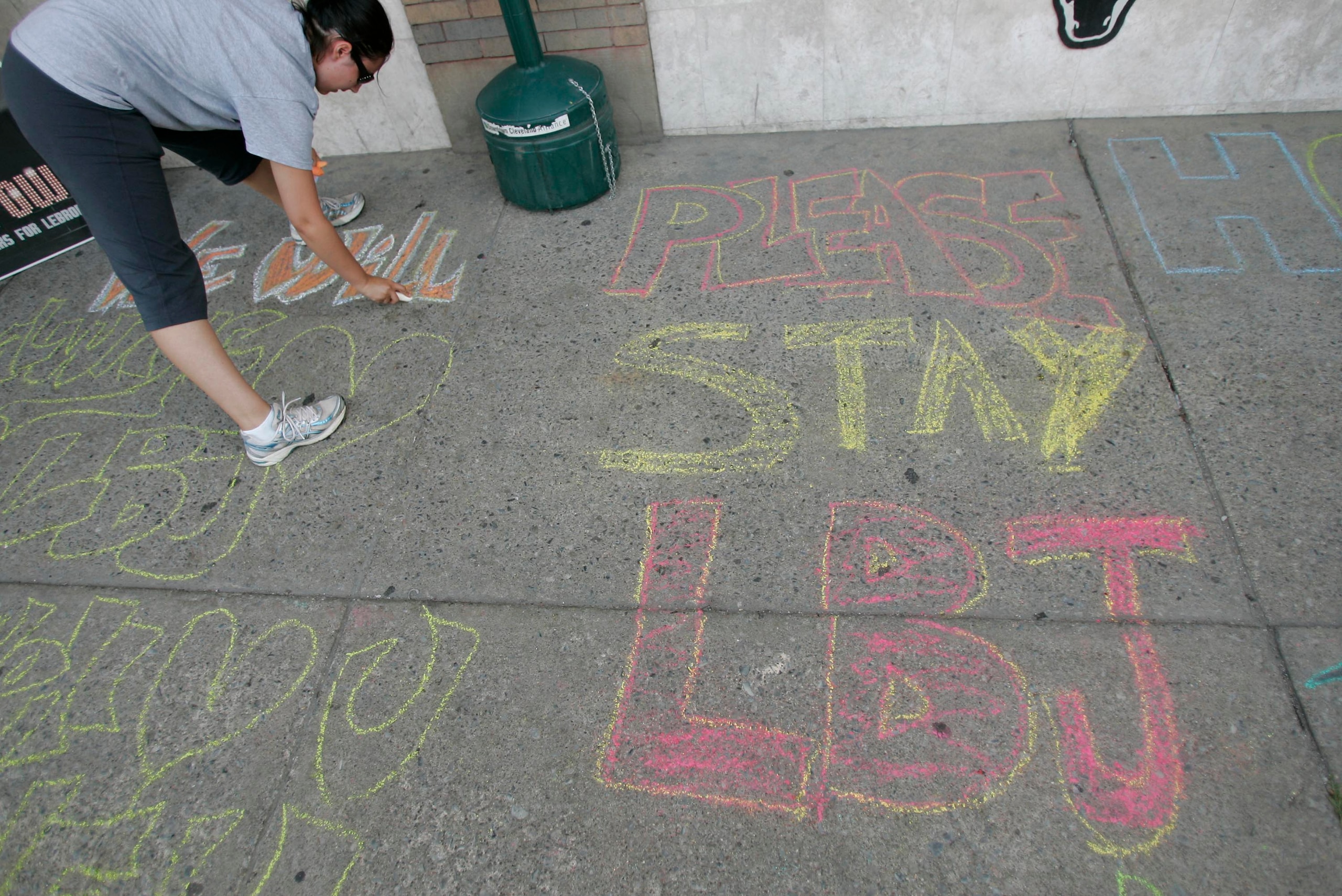 CLEVELAND - JULY 8: Selina Rivera writes with chalk on a sidewalk outside a bar before the LeBron James Television Special July 8, 2010 in Cleveland, Ohio. The two-time Most Valuable Player has the choice of remaining with the Cleveland Cavaliers or sign CLEVELAND - JULY 8: Selina Rivera writes with chalk on a sidewalk outside a bar before the LeBron James Television Special July 8, 2010 in Cleveland, Ohio. The two-time Most Valuable Player has the choice of remaining with the Cleveland Cavaliers or sign