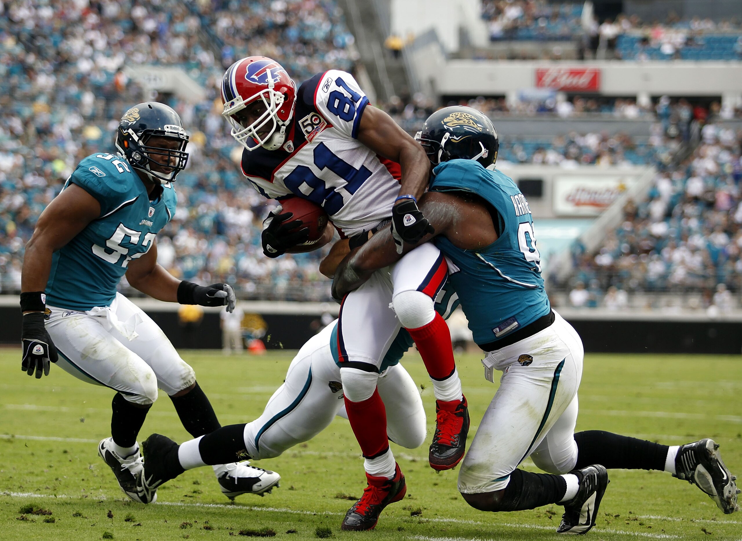 JACKSONVILLE, FL - NOVEMBER 22: Reciever Terrell Owens #81 of the Buffalo Bills is brought down by Jacksonville Jaguars defender Derrick Harvey #91 at Jacksonville Municipal Stadium on November 22, 2009 in Jacksonville, Florida.  (Photo by Marc Serota/Get