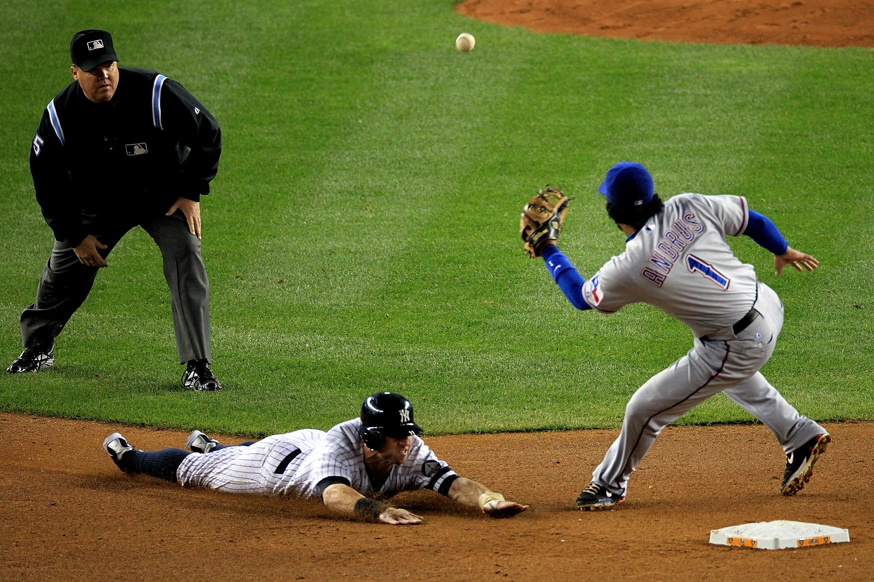 NEW YORK - OCTOBER 18:  Brett Gardner #11 of the New York Yankees steals second base as Elvis Andrus #1 of the Texas Rangers fails to field throw during Game Three of the ALCS during the 2010 MLB Playoffs at Yankee Stadium on October 18, 2010 in New York,