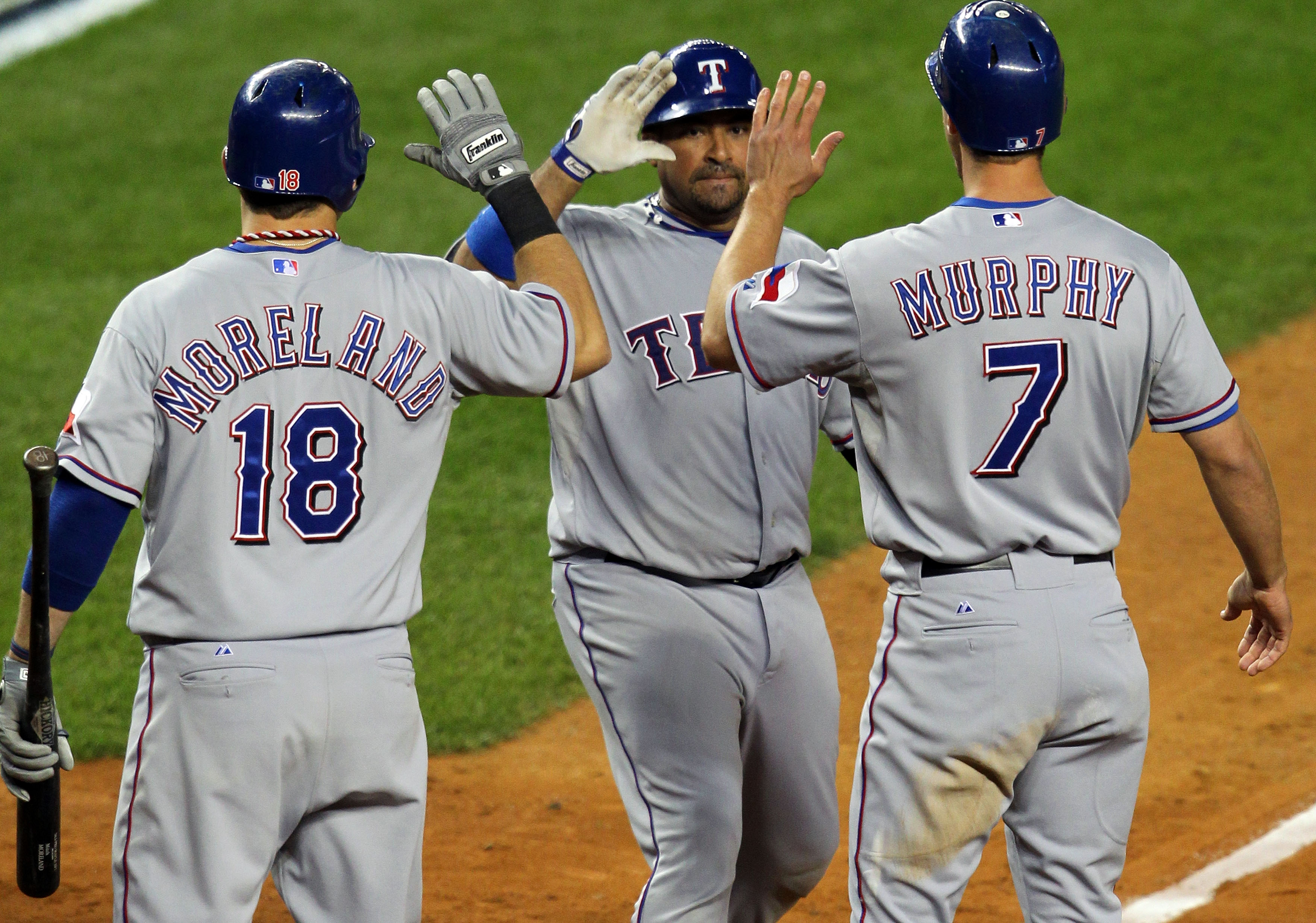 NEW YORK - OCTOBER 19:  Bengie Molina #11 of the Texas Rangers celebrates after hitting a three-run home run in the top of the sixth inning against A.J. Burnett #34 of the New York Yankees with teammates Mitch Moreland #18 and David Murphy #7 in Game Four