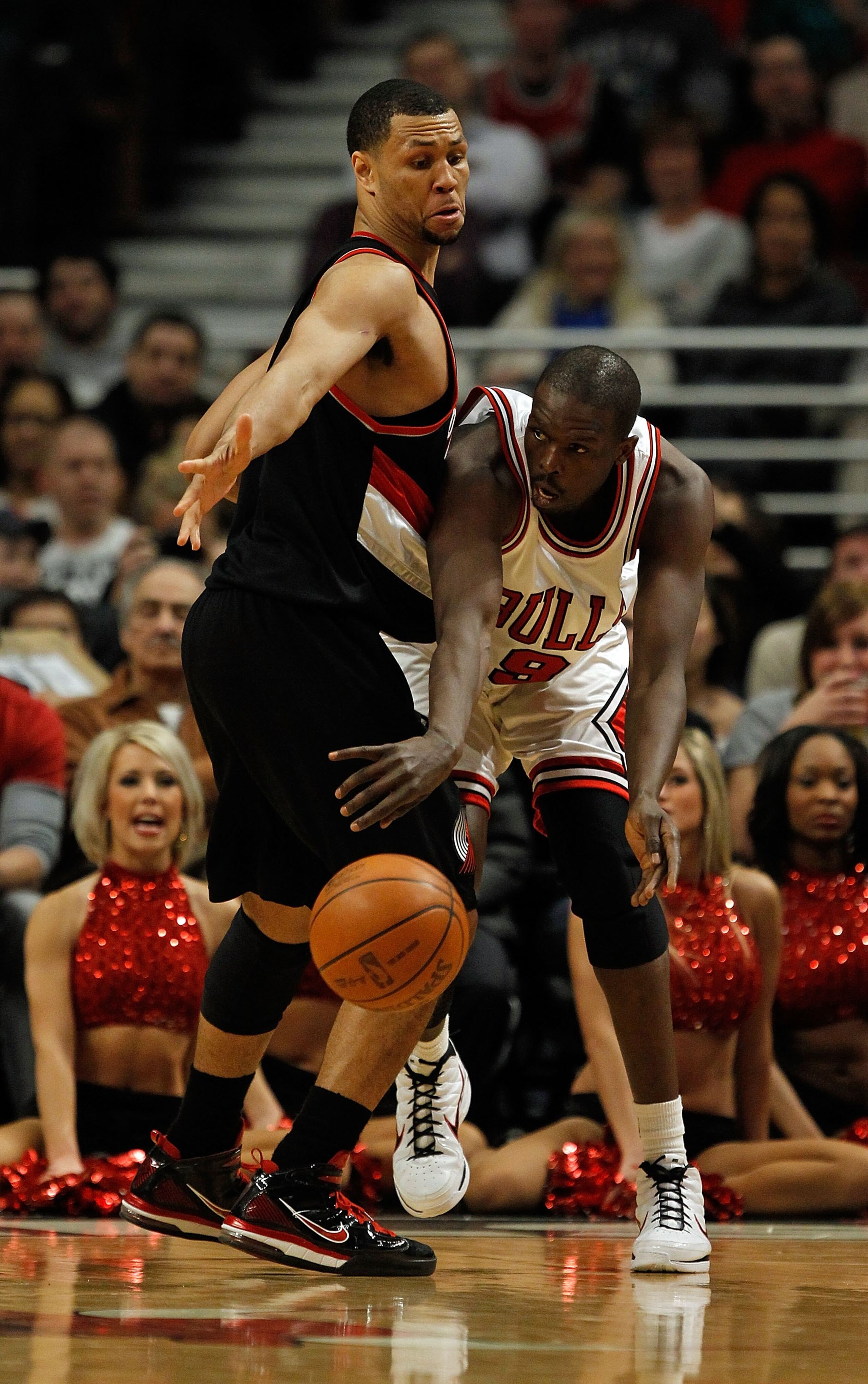 CHICAGO - FEBRUARY 26: Loul Deng #9 of the Chicago Bulls passes around Brnadon Roy #7 of the Portland Trail Blazers at the United Center on February 26, 2010 in Chicago, Illinois. The Bulls defeated the Trail Blazers 115-111 in overtime. NOTE TO USER: Use