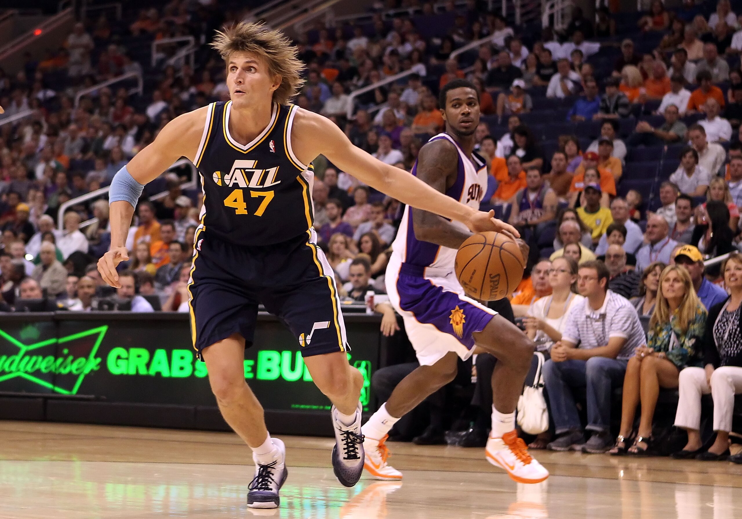 PHOENIX - OCTOBER 12:  Andrei Kirilenko #47 of the Utah Jazz drives the ball past Earl Clark #55 of the Phoenix Suns during the preseason NBA game at US Airways Center on October 12, 2010 in Phoenix, Arizona. NOTE TO USER: User expressly acknowledges and 