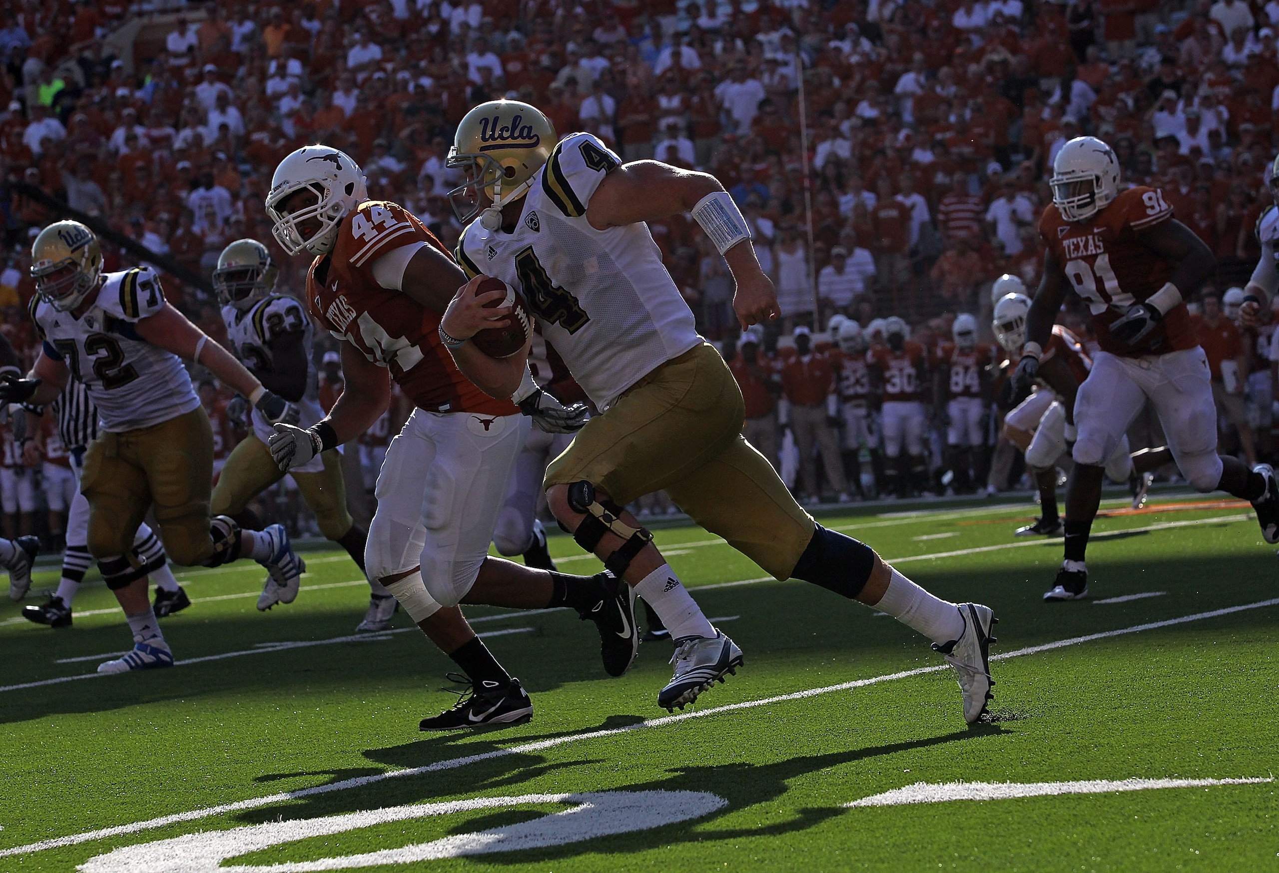 AUSTIN, TX - SEPTEMBER 25:  Quarterback Kevin Prince #4 of the UCLA Bruins runs the ball past Jackson Jeffcoat #44 of the Texas Longhorns at Darrell K Royal-Texas Memorial Stadium on September 25, 2010 in Austin, Texas.  (Photo by Ronald Martinez/Getty Im