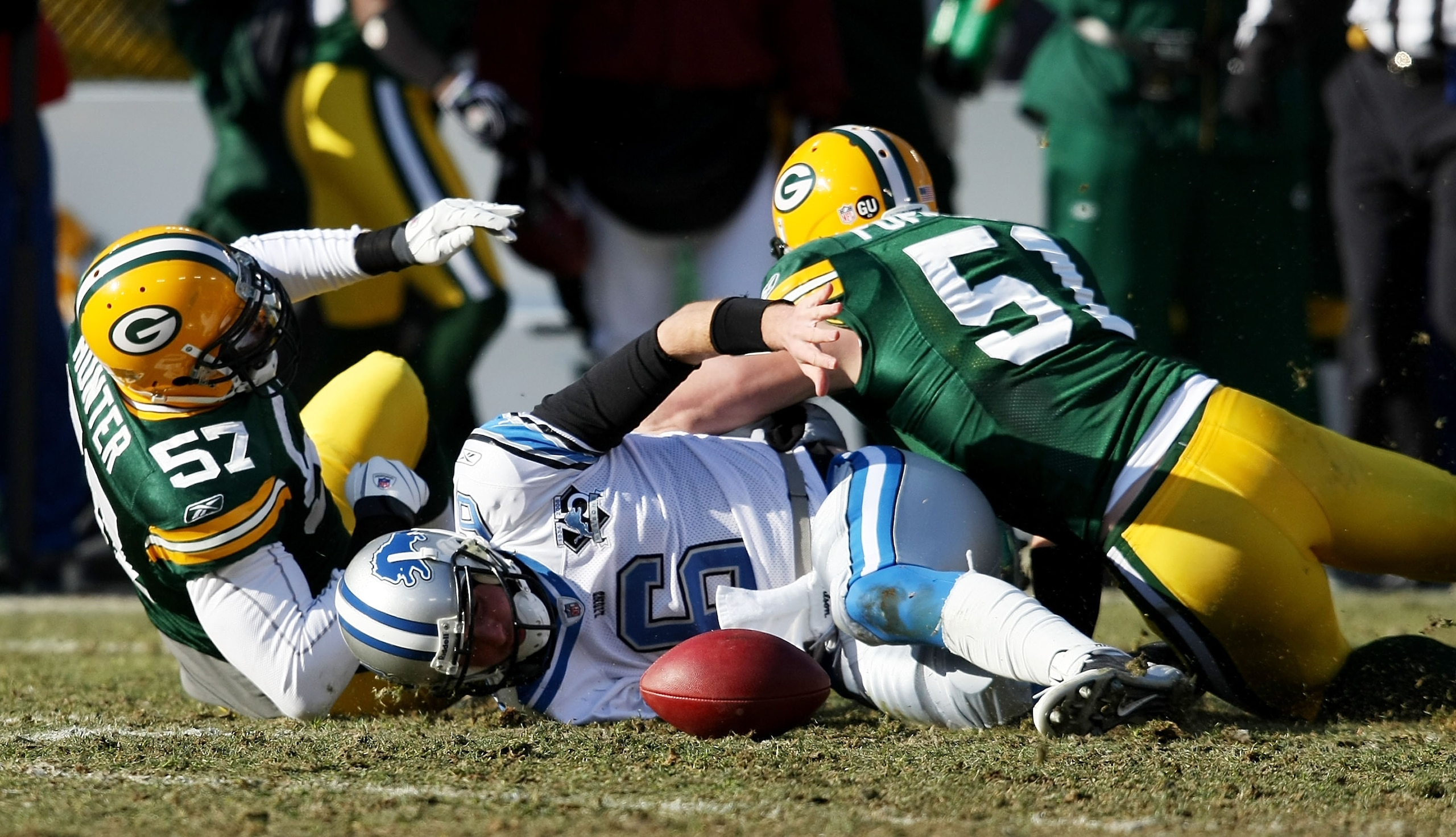 GREEN BAY, WI - DECEMBER 28: Dan Orlovsky #6 of the Detroit Lions looses the ball after being tackled by Jason Hunter #57 and Brady Poppinga #51 of the Green Bay Packers on December 28, 2008 at Lambeau Field in Green Bay, Wisconsin. The Packers defeated t