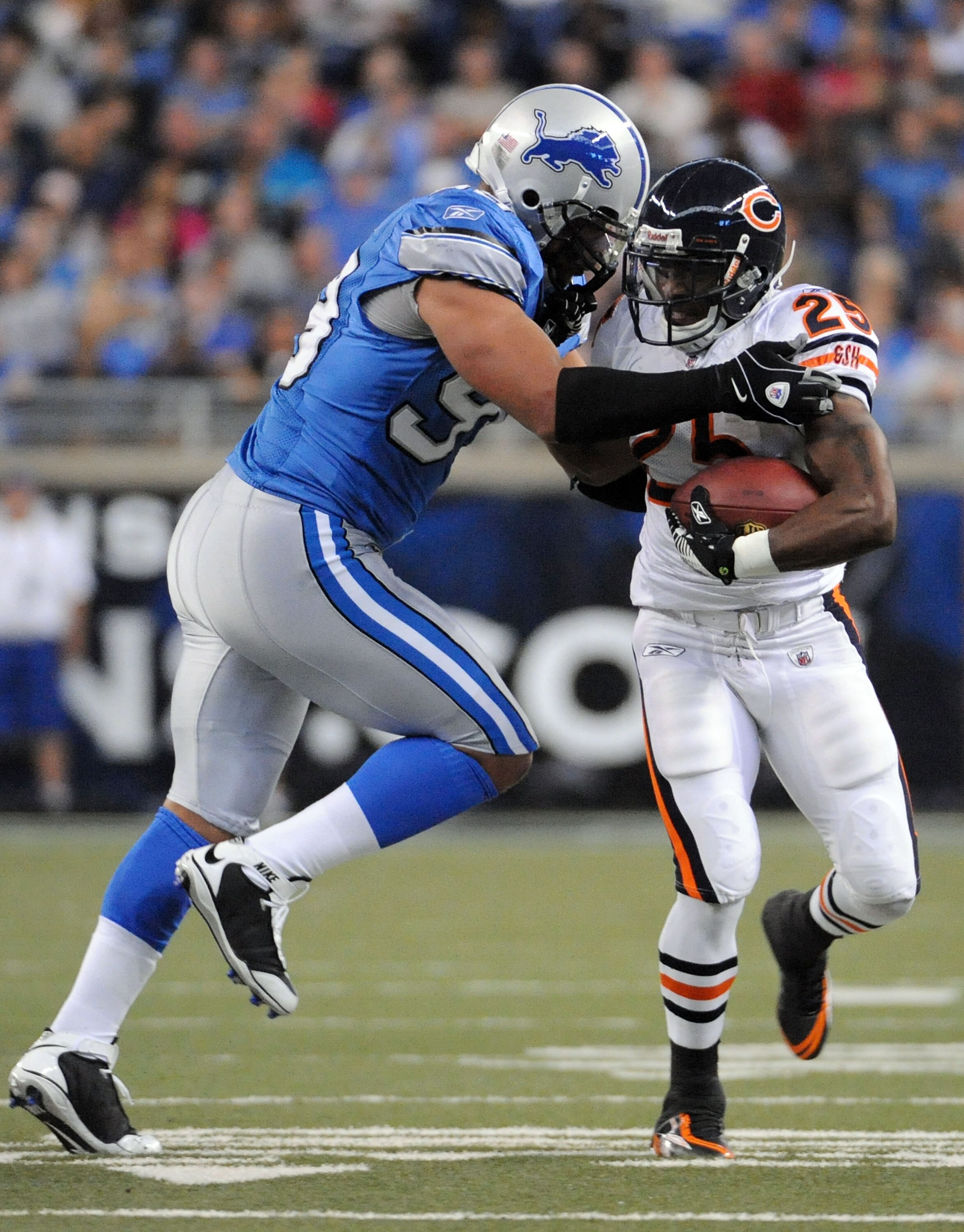 DETROIT - OCTOBER 05:  Garrett Wolfe #25 of the Chicago Bears is tackled by Dewayne White #99 of the Detroit Lions during the first quarter at Ford Field on October 5, 2008 in Detroit, Michigan.  The Bears won 34-7.  (Photo by Harry How/Getty Images)