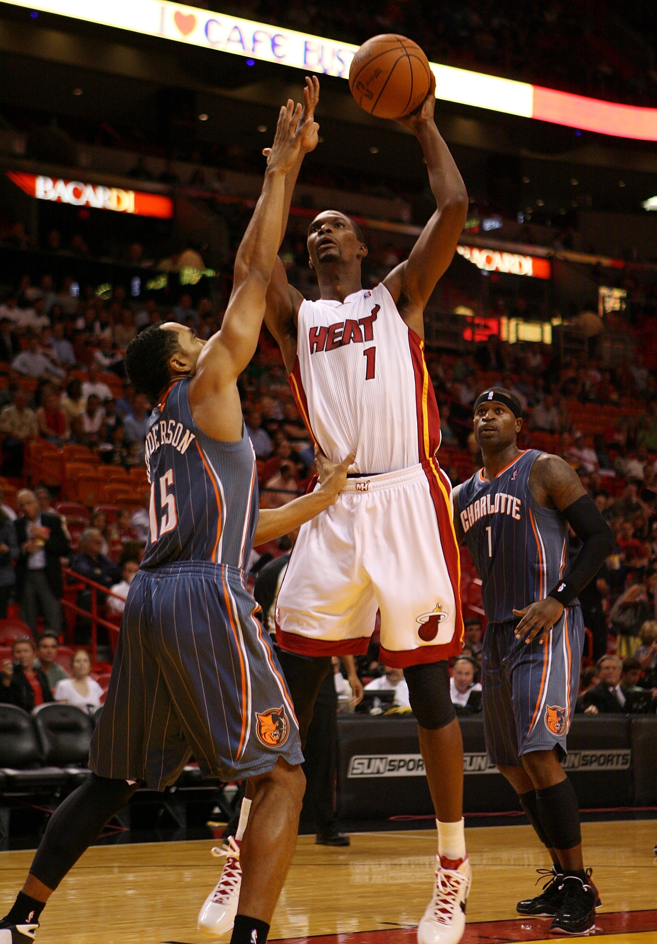 MIAMI - OCTOBER 18:  Center Chris Bosh #1 of the Miami Heat shoots over Guard Gerald Henderson #15  of the Charlotte Bobcats on October 18, 2010 at the American Airlines arena in Miami, Florida.  NOTE TO USER: User expressly acknowledges and agrees that,