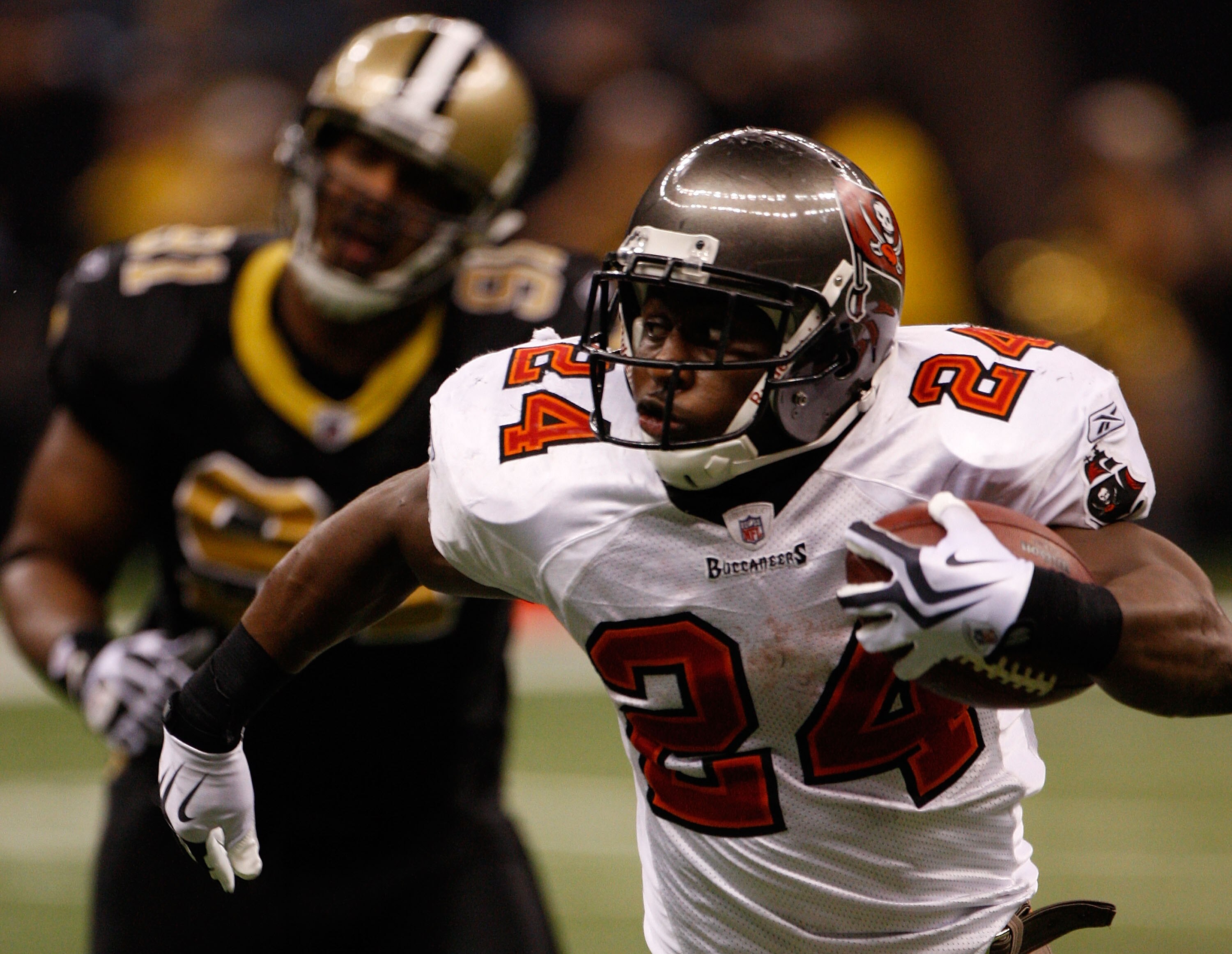 NEW ORLEANS - DECEMBER 27:  Cadillac Williams #24 of the Tampa Bay Buccaneers runs past Will Smith #91 of the New Orleans Saints at the Louisiana Superdome on December 27, 2009 in New Orleans, Louisiana.  (Photo by Chris Graythen/Getty Images)