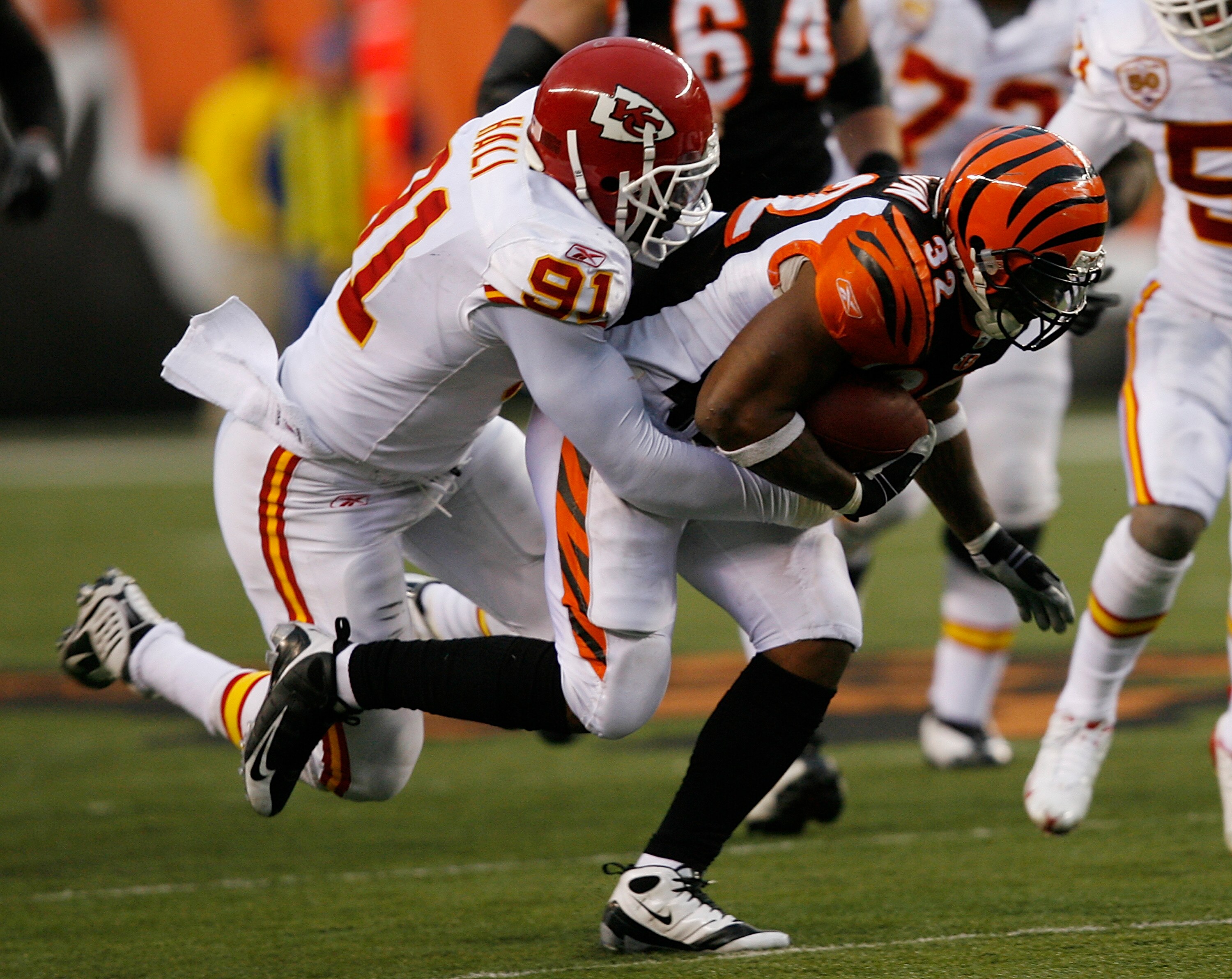 CINCINNATI - DECEMBER 27: Cedric Benson #32 of the Cincinnati Bengals is tackled by Tamba Hali #91 of the Kansas City Chiefs in their NFL game at Paul Brown Stadium December 27, 2009 in Cincinnati, Ohio.    (Photo by John Sommers II/Getty Images)