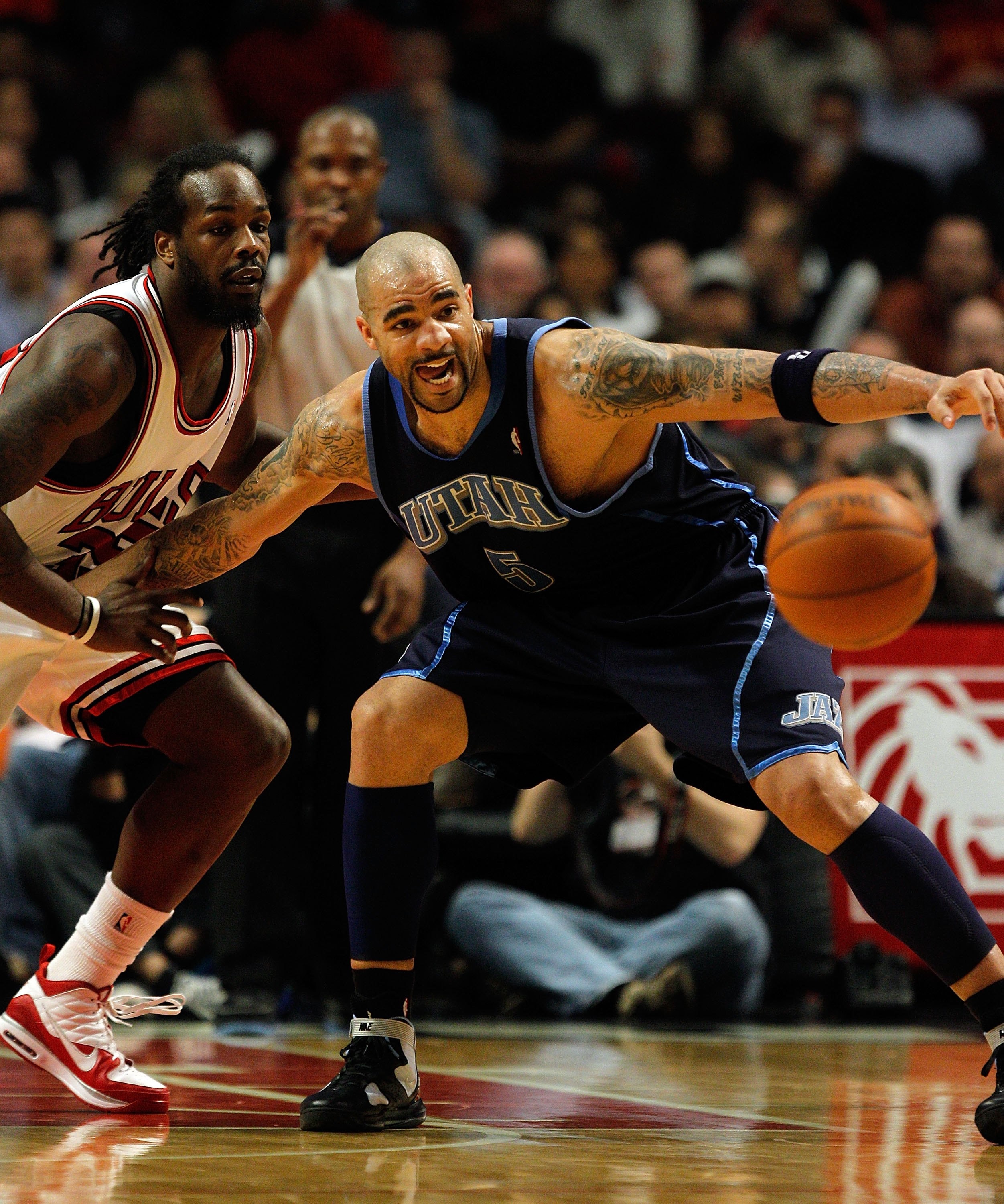 CHICAGO - MARCH 09: Carlos Boozer #5 of the Utah Jazz looks to recover a loose ball as he holds off Chris Richard #35 of the Chicago Bulls at the United Center on March 9, 2010 in Chicago, Illinois. The Jazz defeated the Bulls 132-108. NOTE TO USER: User