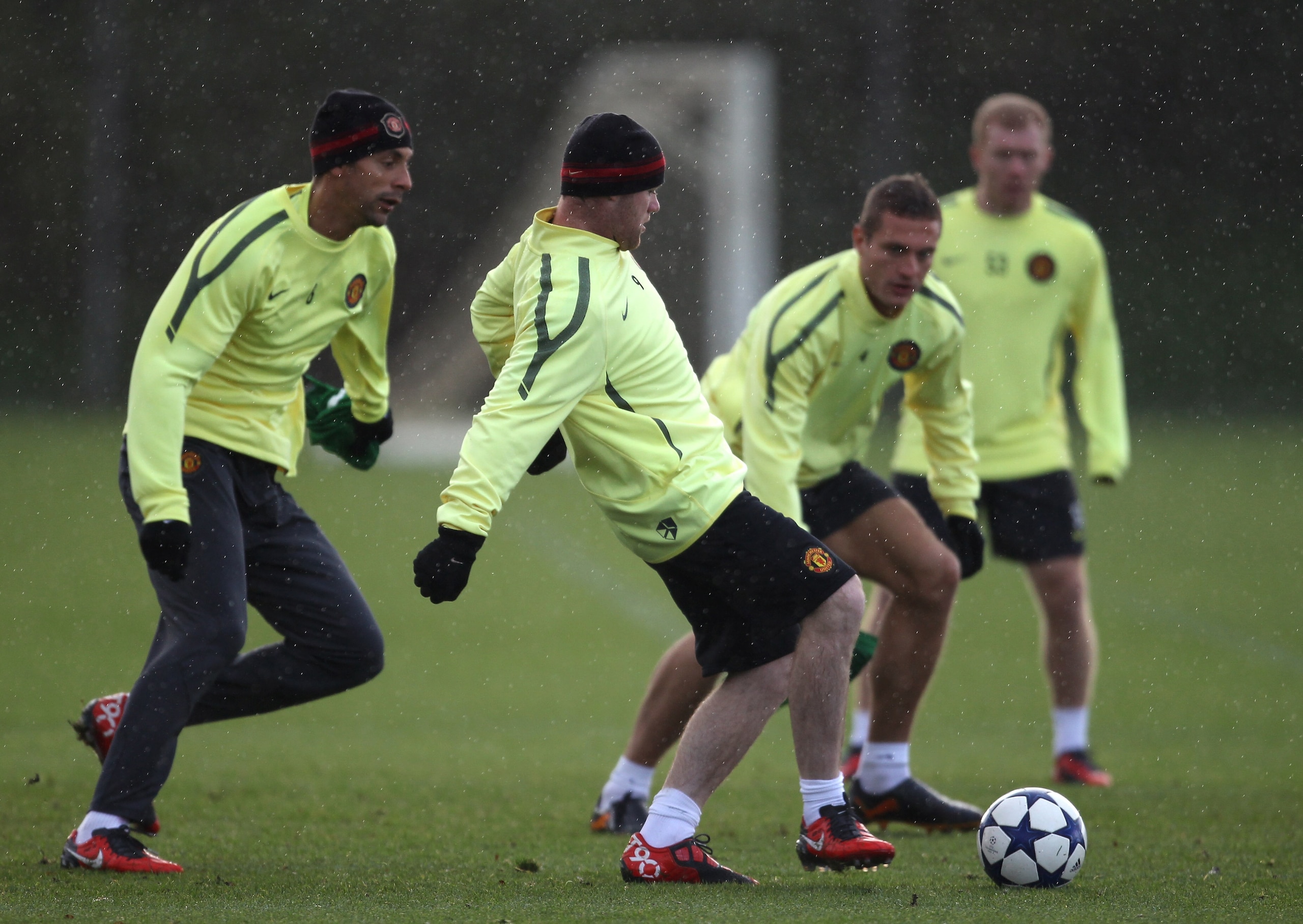 MANCHESTER, ENGLAND - OCTOBER 19:  Wayne Rooney of Manchester United passes the ball under pressure from Rio Ferdinand and Nemanja Vidic during a training session at the Carrington Training Complex on October 19, 2010 in Manchester, England.  (Photo by Al