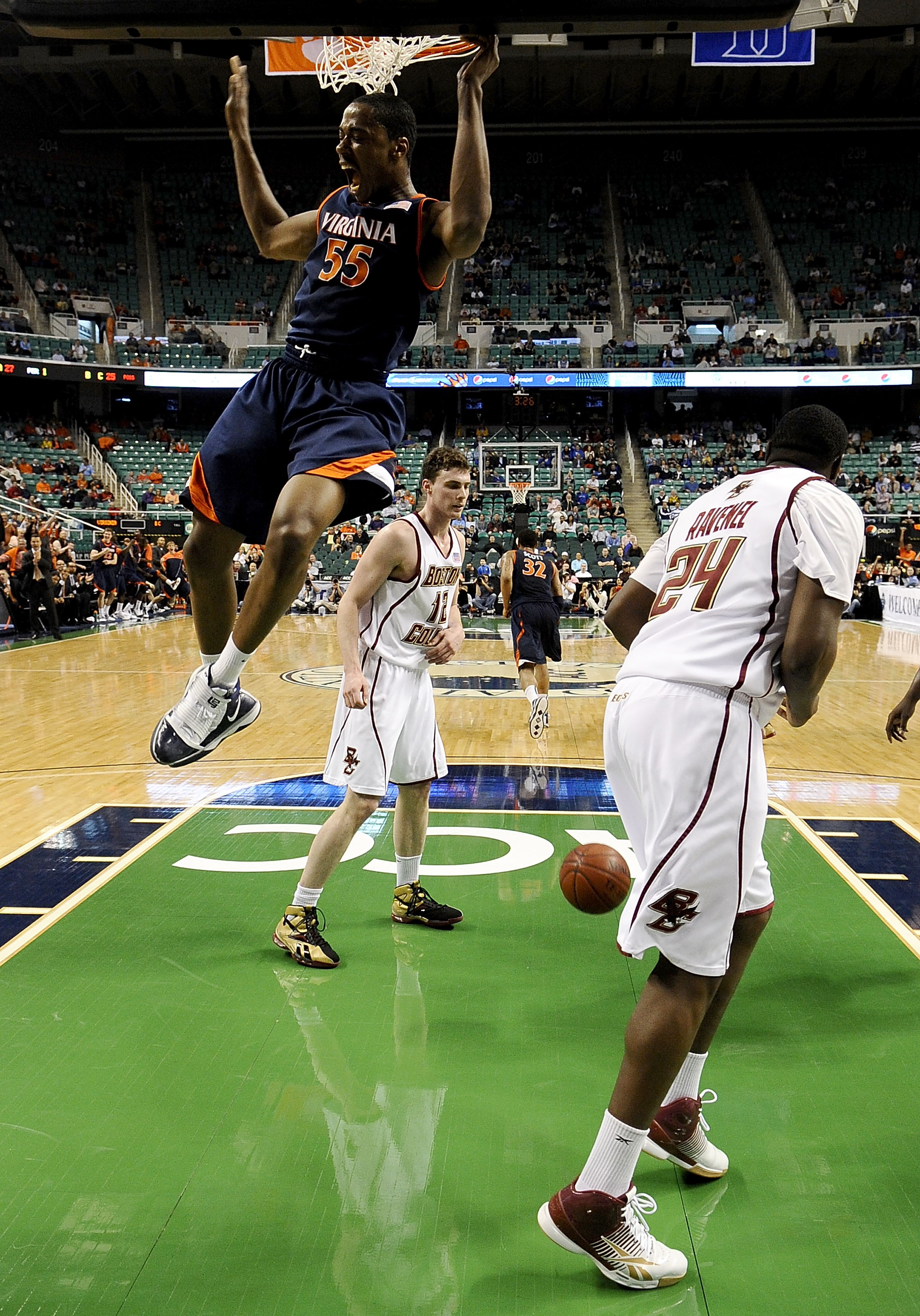 GREENSBORO, NC - MARCH 11:  Jerome Meyinsse #55 of the University of Virginia Cavaliers dunks in front of Evan Ravenel #24 and Joe Trapani #12 of the Boston College Eagles in their first round game in the 2010 ACC Men's Basketball Tournament at the Greens