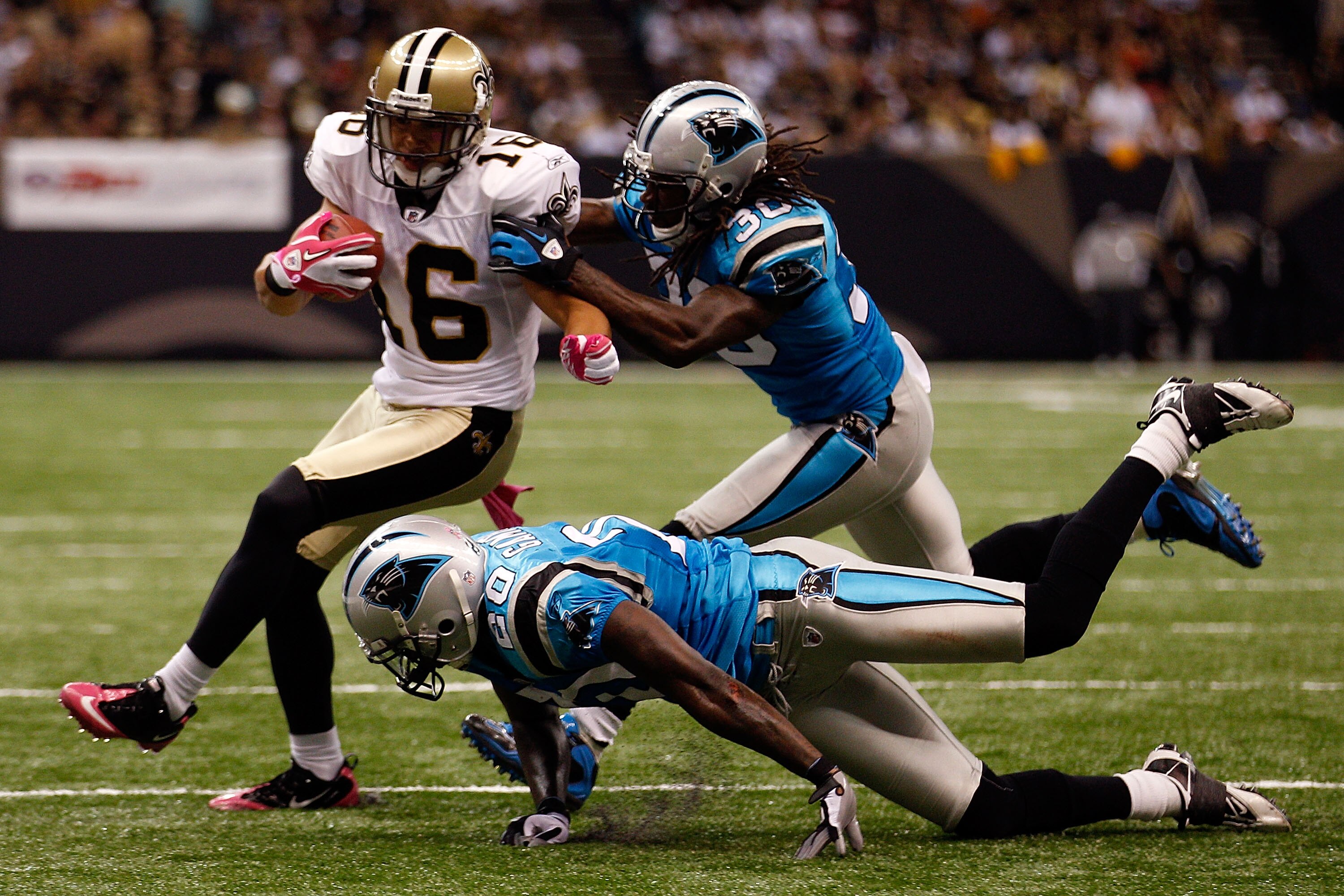 NEW ORLEANS - OCTOBER 03:  Lance Moore #16 of the New Orleans Saints is pushed out of bounds by Chris Gamble #20 and Charles Godfrey #30 of the Carolina Panthers at the Louisiana Superdome on October 3, 2010 in New Orleans, Louisiana.  of the Carolina Pan