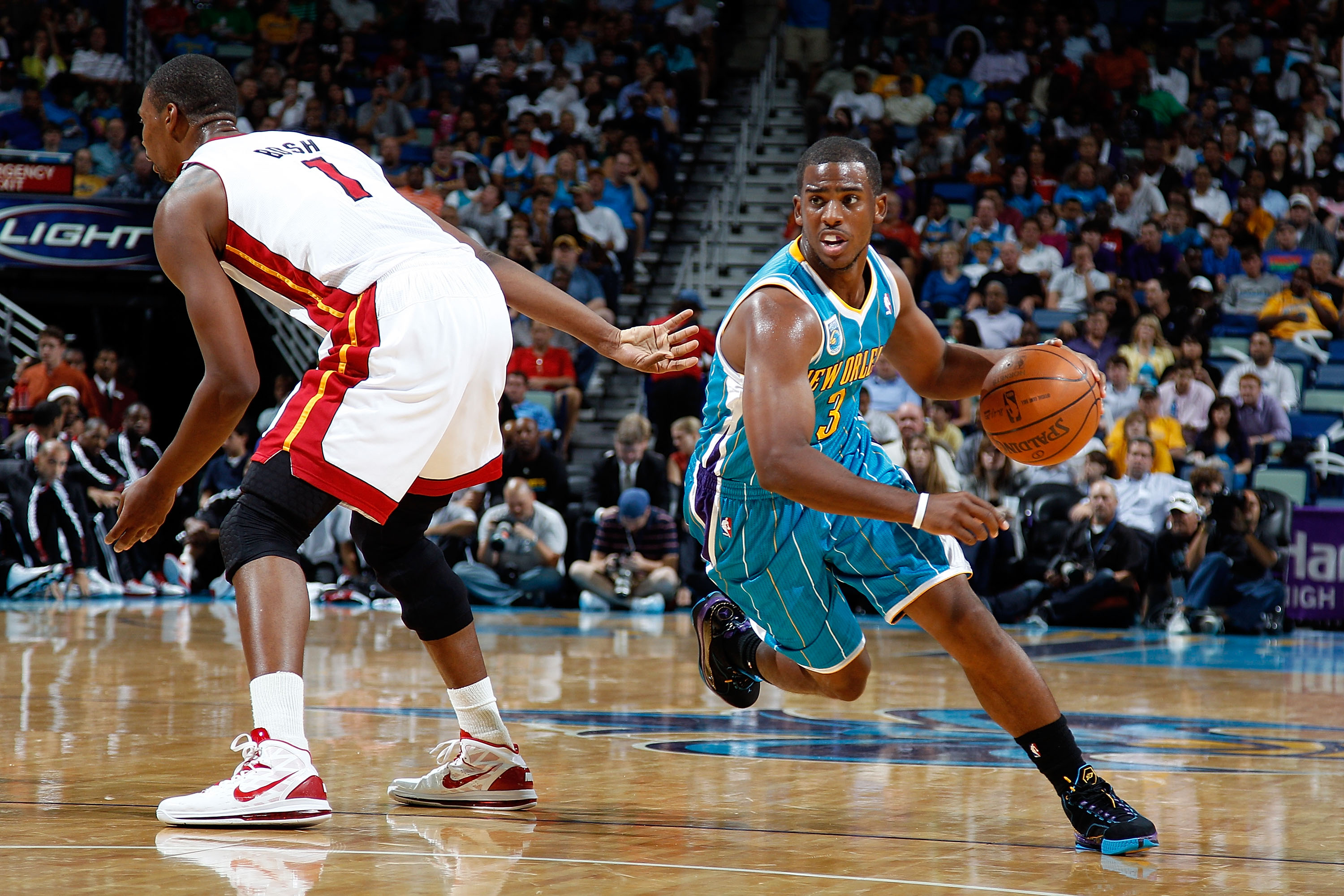 NEW ORLEANS - OCTOBER 13:  Chris Paul #3 of the New Orleans Hornets drives the ball around Chris Bosh #1 of the Miami Heat at the New Orleans Arena on October 13, 2010 in New Orleans, Louisiana. NOTE TO USER: User expressly acknowledges and agrees that, b