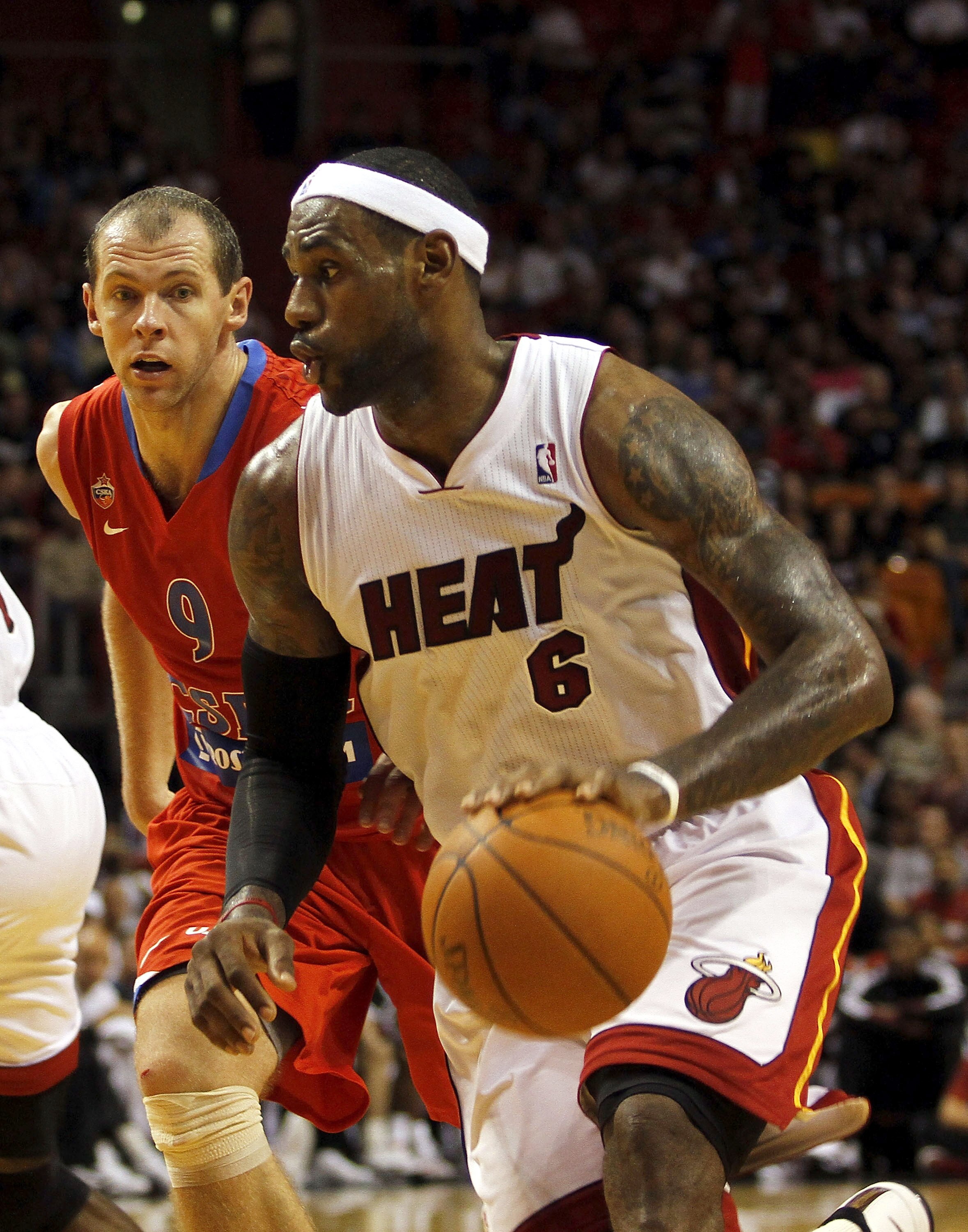 MIAMI - OCTOBER 12:  Forward LeBron James #6 of the Miami Heat drives around forward Ramunas Siskauskas #9 of CSKA Moscow on October 12, 2010 in Miami, Florida.  Miami heat won 96-85 over CSKA Moscow.  NOTE TO USER: User expressly acknowledges and agrees