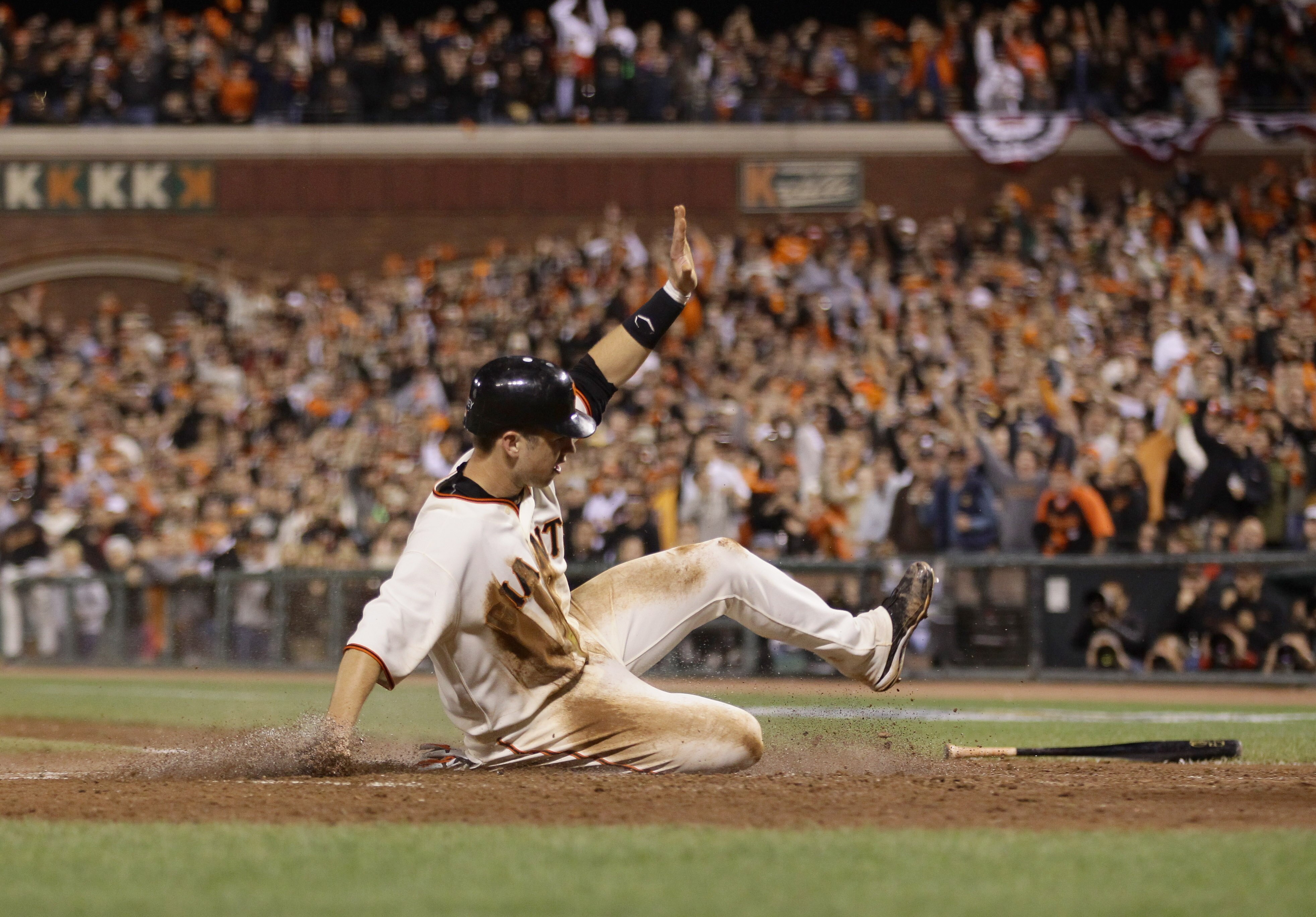 SAN FRANCISCO - OCTOBER 07:  Buster Posey #28 of the San Francisco Giants slides safely home against the Atlanta Braves to score on a single by Cody Ross #13 to give the Giants a 1-0 lead in the fourth inning of game 1 of the NLDS at AT&T Park on October 