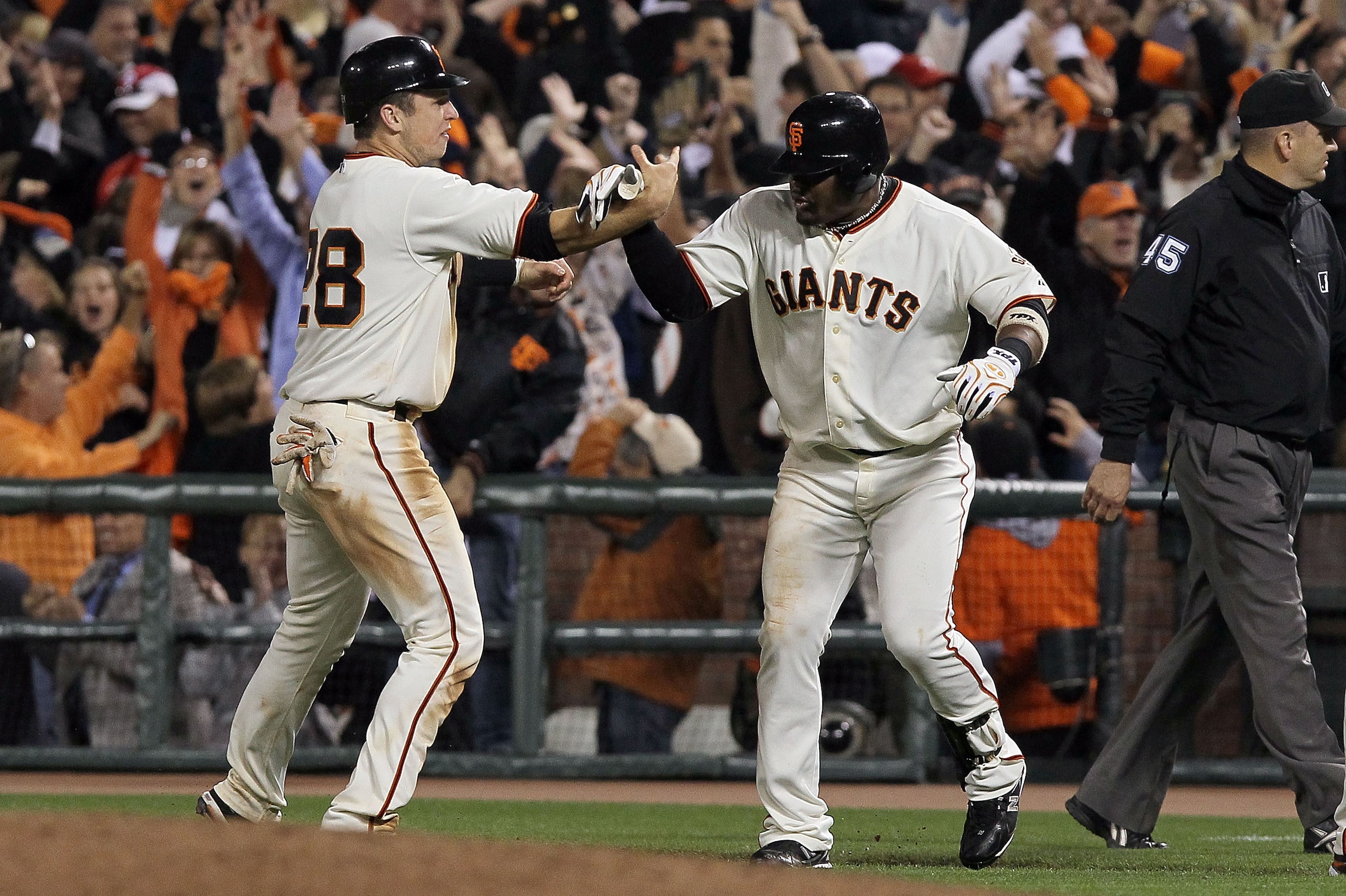 SAN FRANCISCO - OCTOBER 20:  Juan Uribe #5 of the San Francisco Giants celebrates with Buster Posey #28 after hitting a sacrifice fly that scored Aubrey Huff #17 to win 6-5 over the Philadelphia Phillies in Game Four of the NLCS during the 2010 MLB Playof