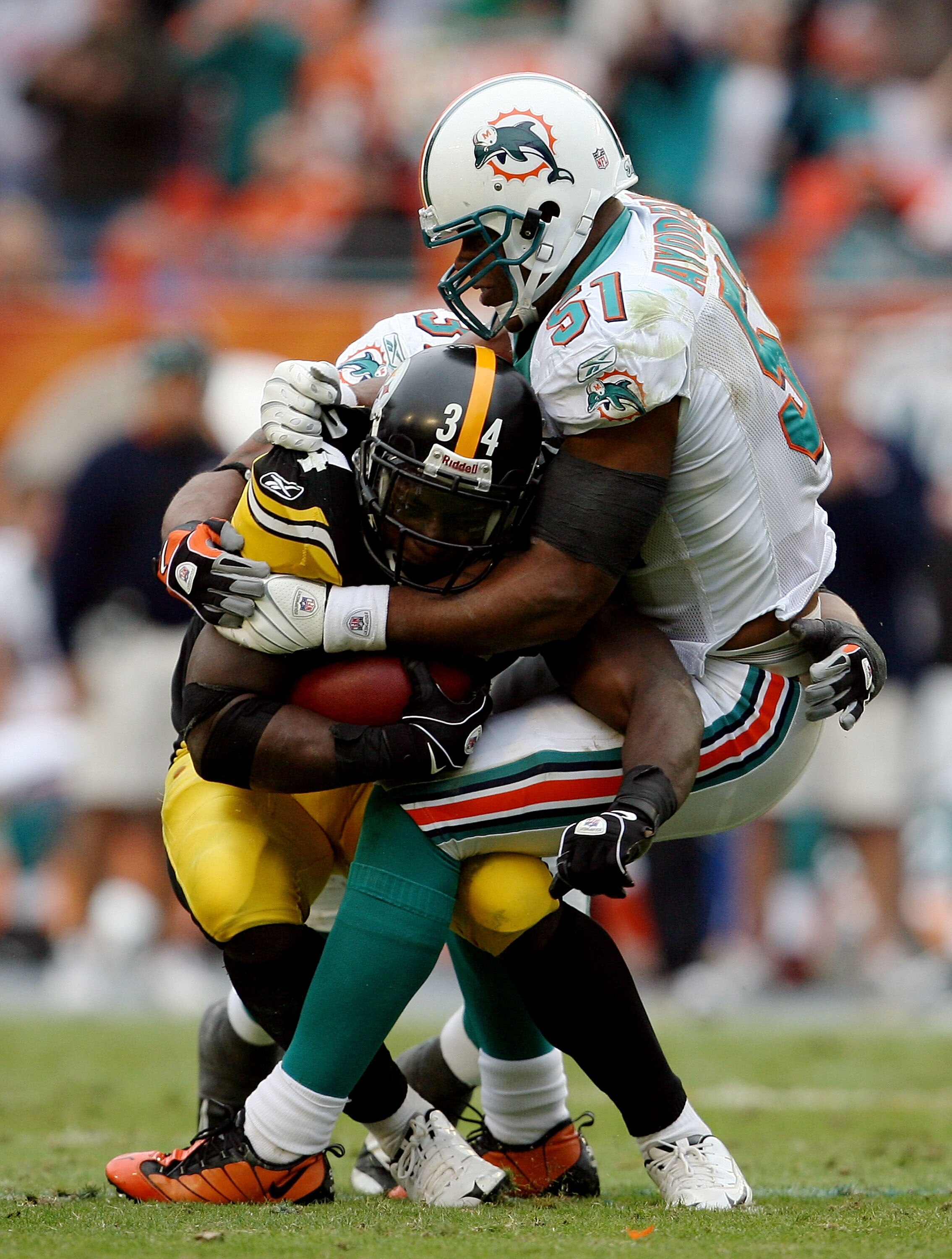 MIAMI - JANUARY 03:  Running back Rashard Mendenhall #34 of the Pittsburgh Steelers is brought down by linebacker Akin Ayodele #51 of the Miami Dolphins at Land Shark Stadium on January 3, 2010 in Miami, Florida. The Steelers defeated the Dolphins 30-24.